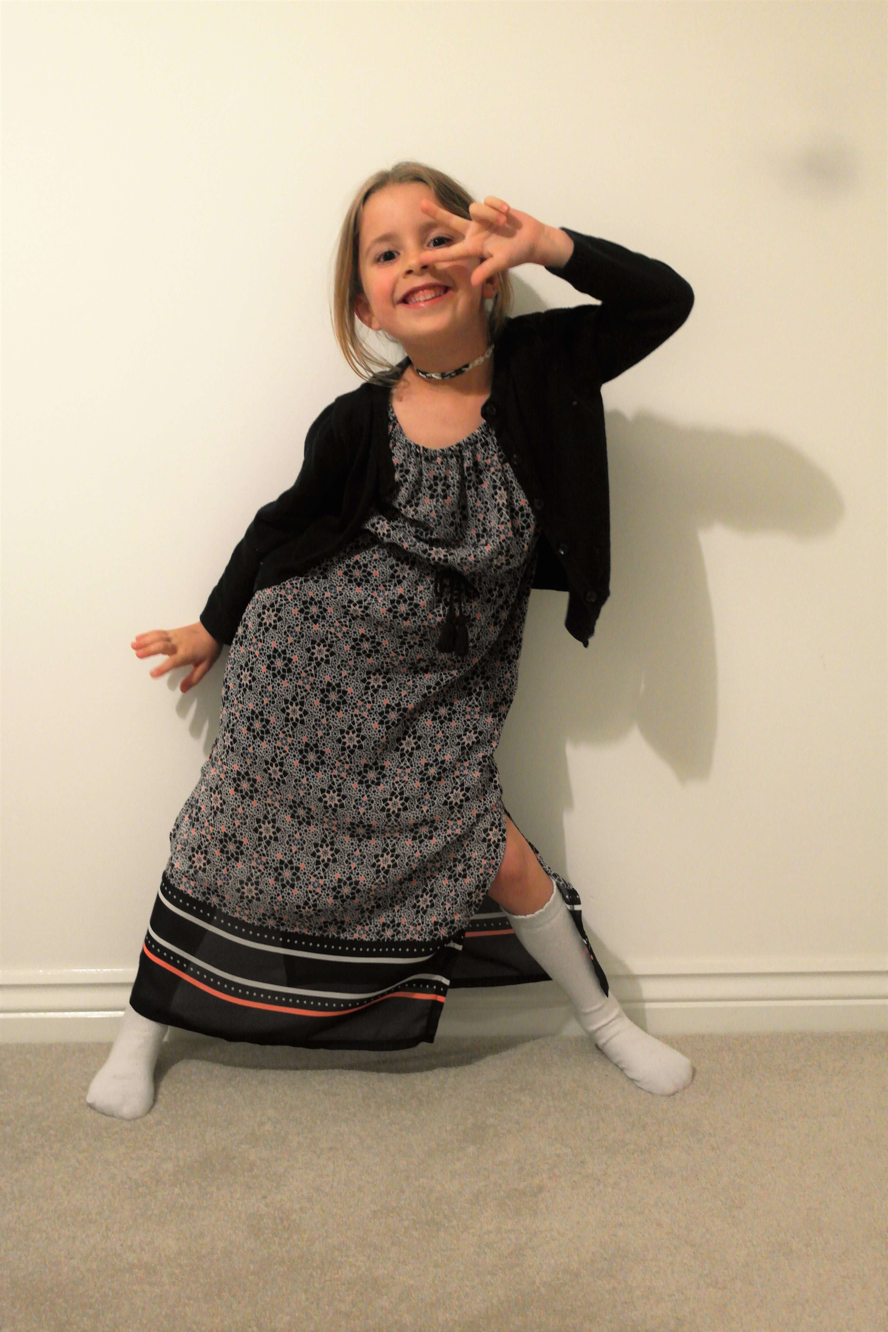 beg's style wearing black dress and shrug making a peace sign