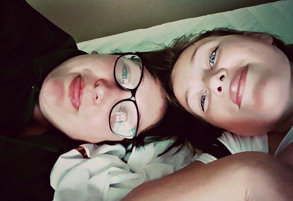 one child really can be enough picture of mum and daughter lying down and pulling tongues