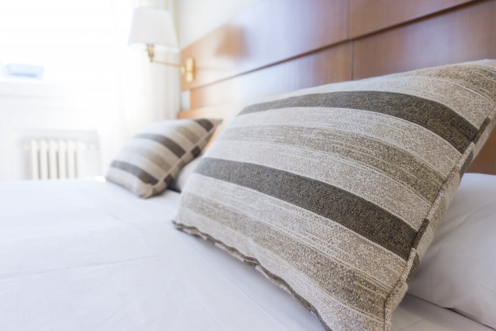 pillows on a bed for a post on sleep tips to ease aches and pains