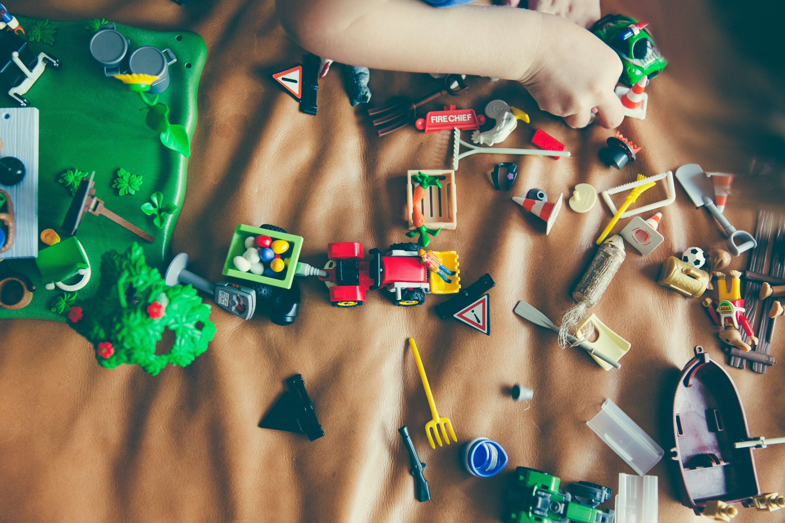 toys sread out on a carpet as a child plays with them making learning fun