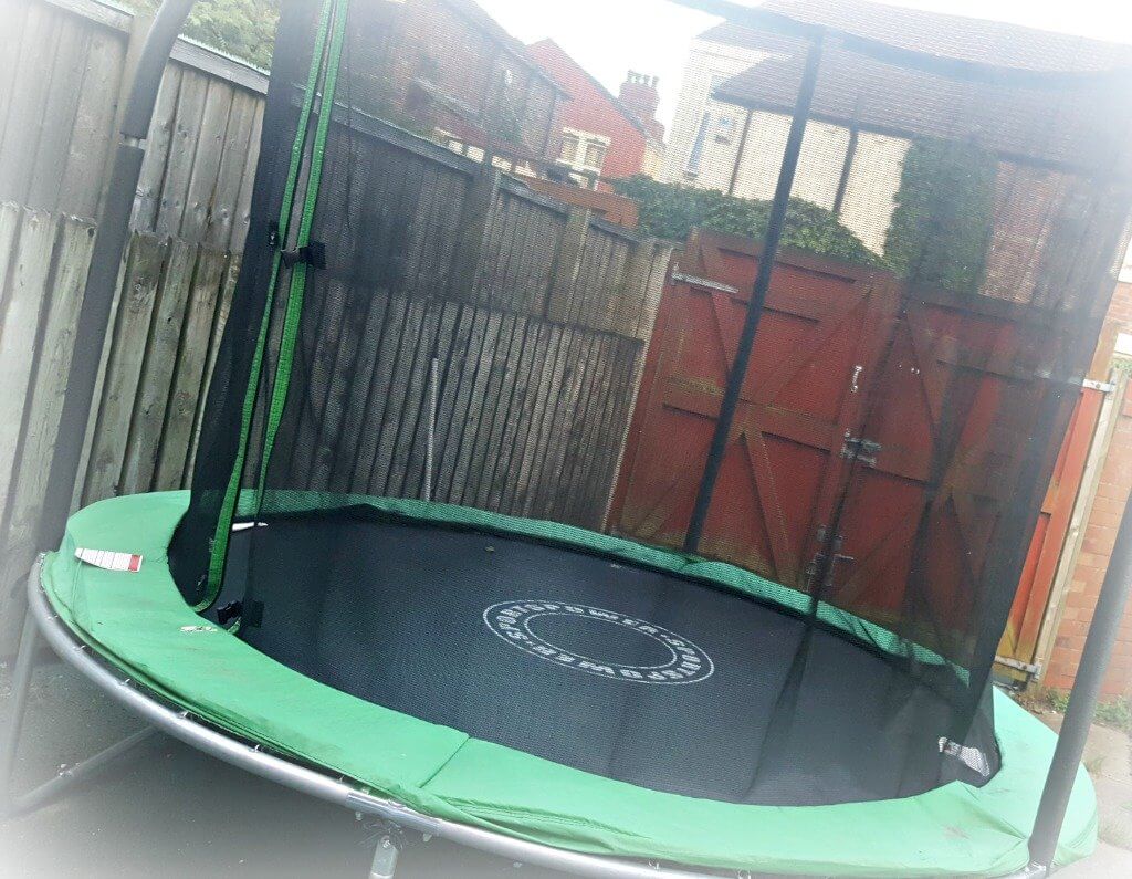 trampoline with safety net in a back garden