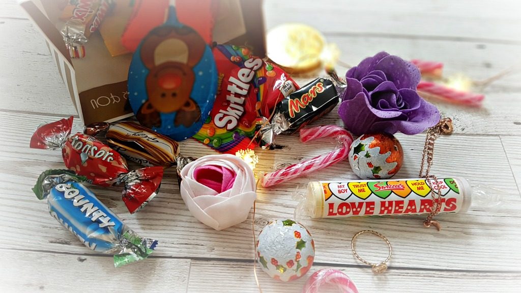 costume jewellery, soap flowers and sweets in a christmas gift bags