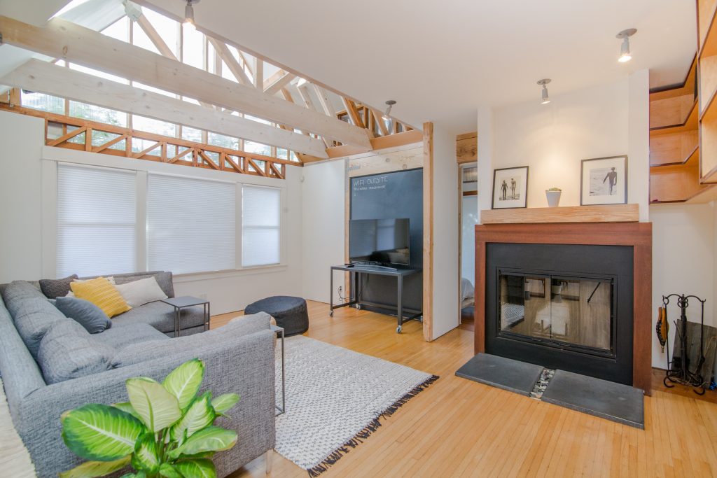 an open lounge area with beams on ceiling and fireplace - buying a family home