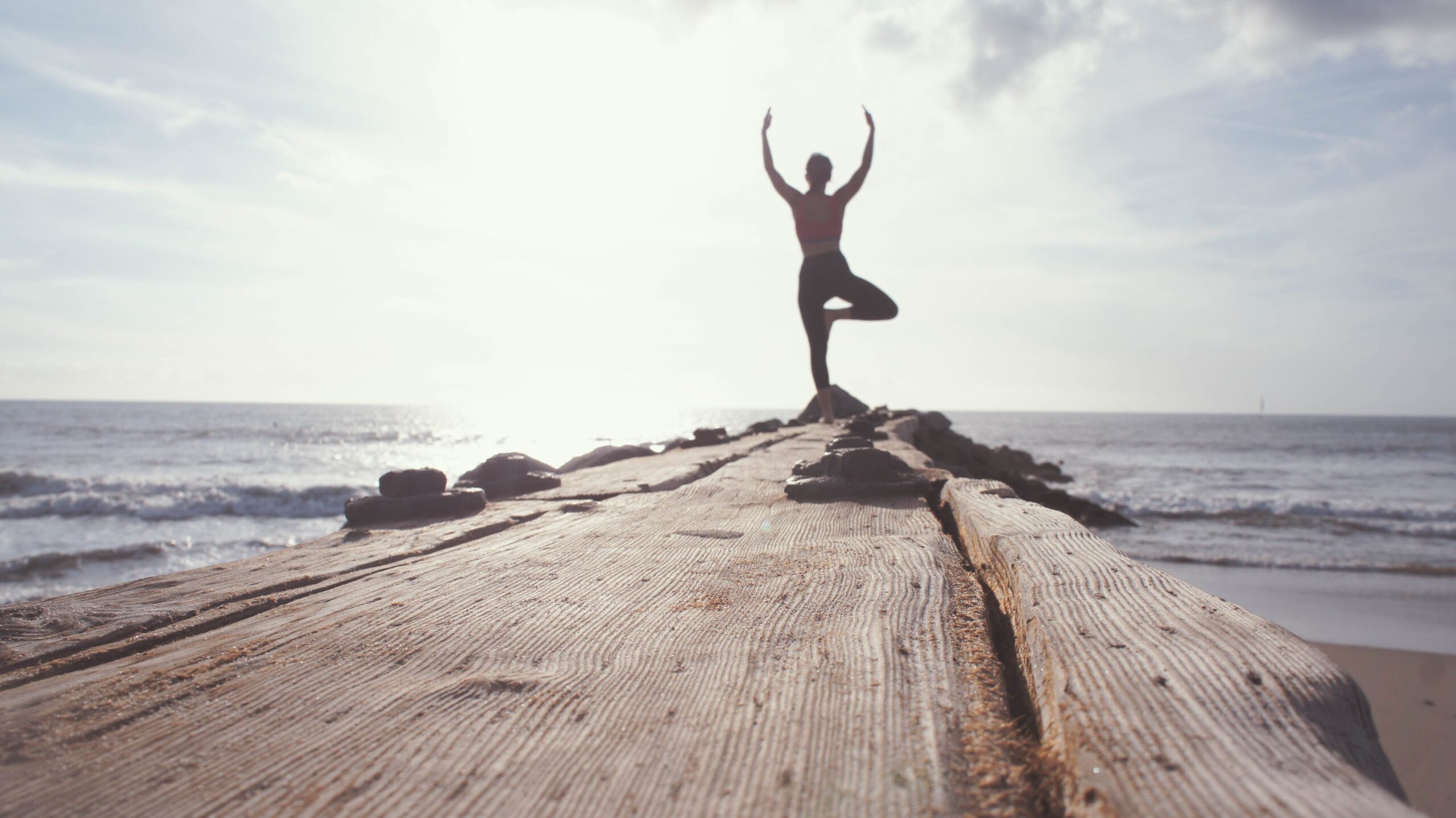 getting healthier - person at the end of a pier in a yoga stance