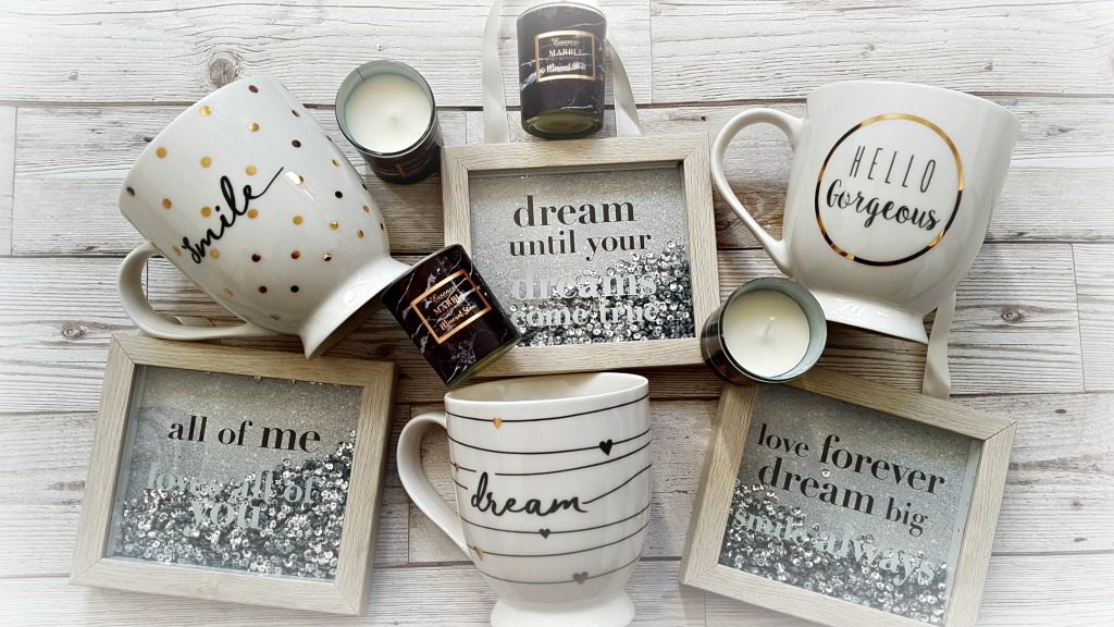 3 sequin wooden frames with quotes, 3 mugs with words on and 4 small glass candles on a wood background from the mothers day range at b&m
