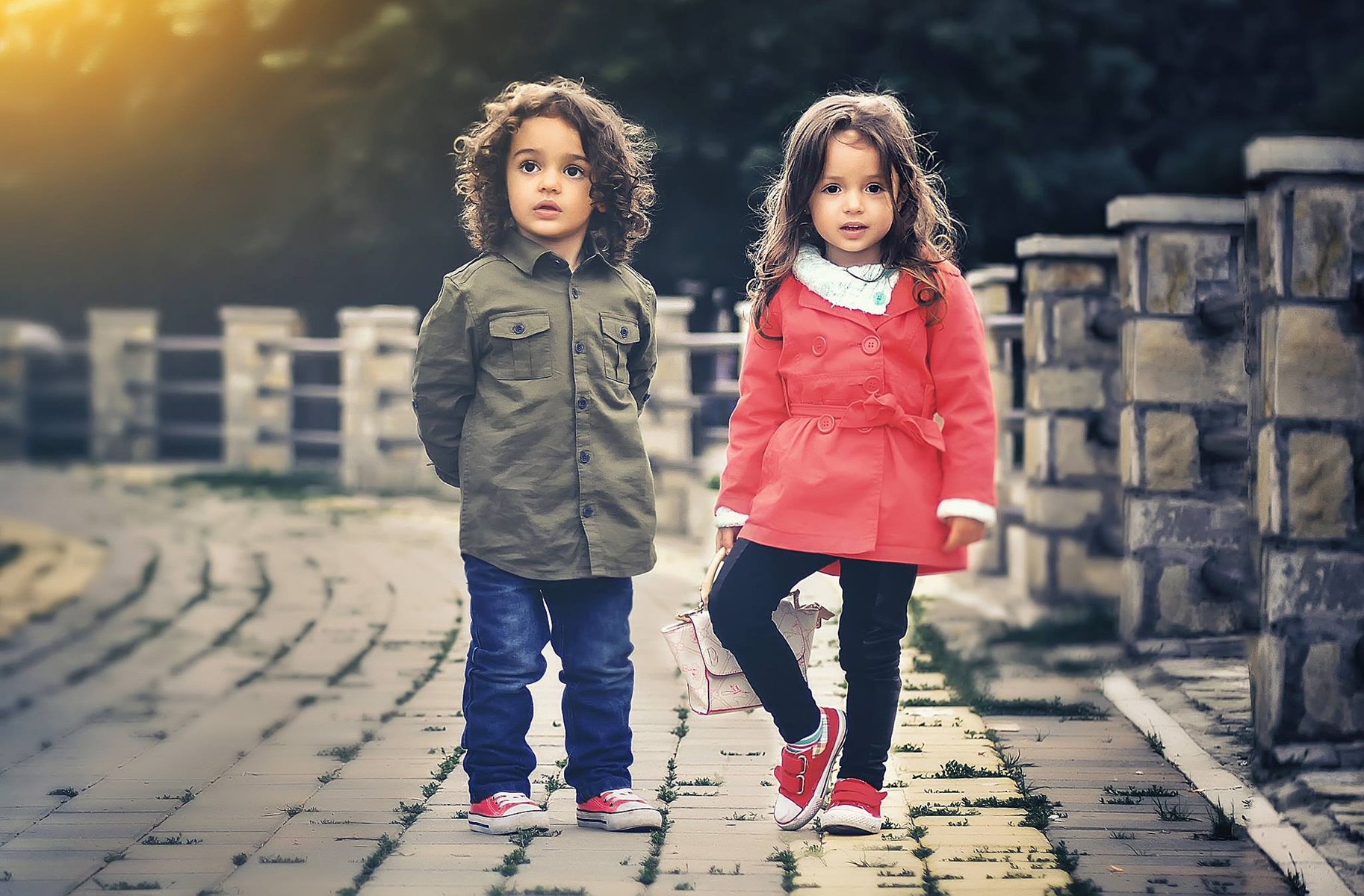 young girl and boy with sneakers on on a bridge