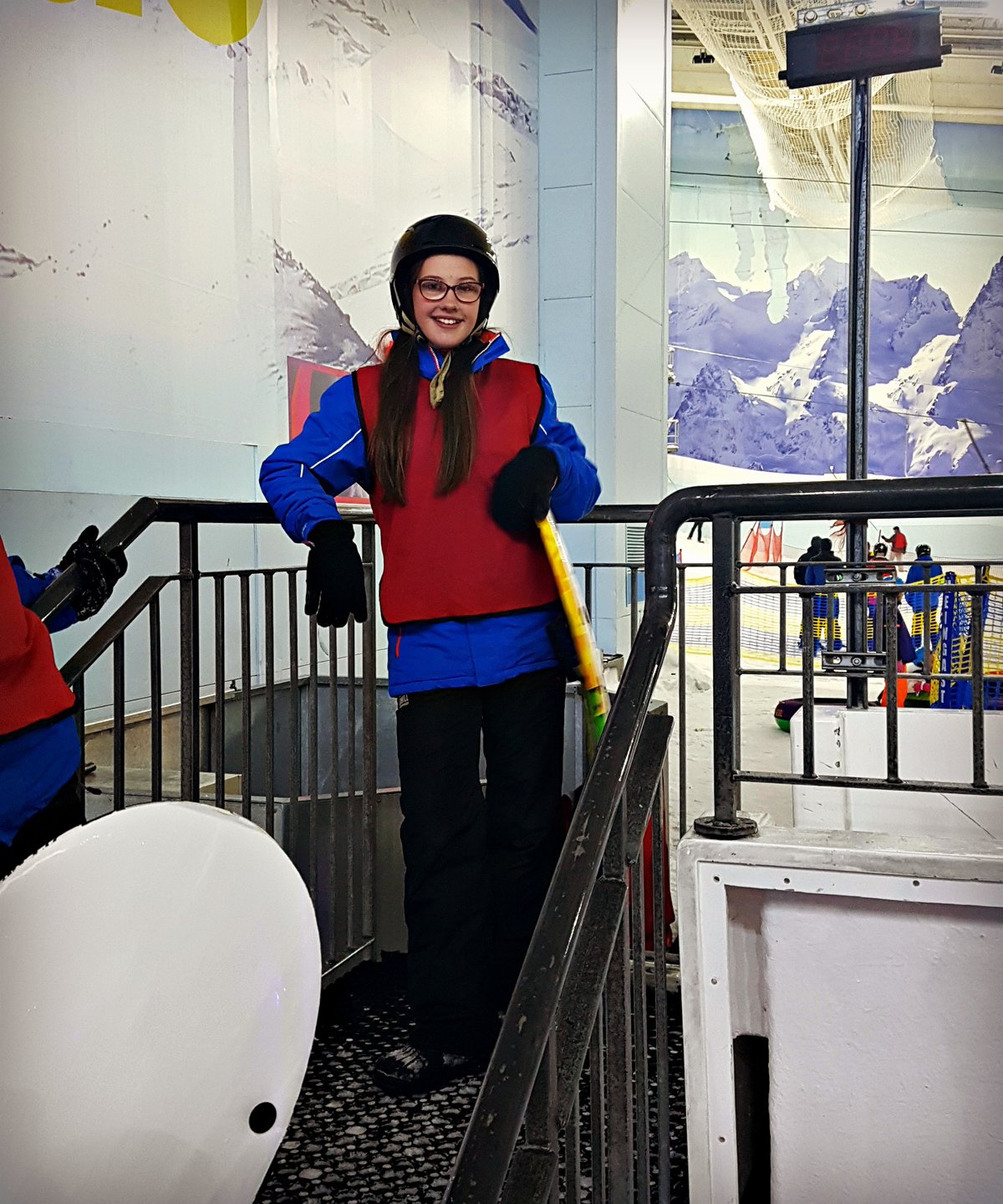 girl in ski clothing standing on steps