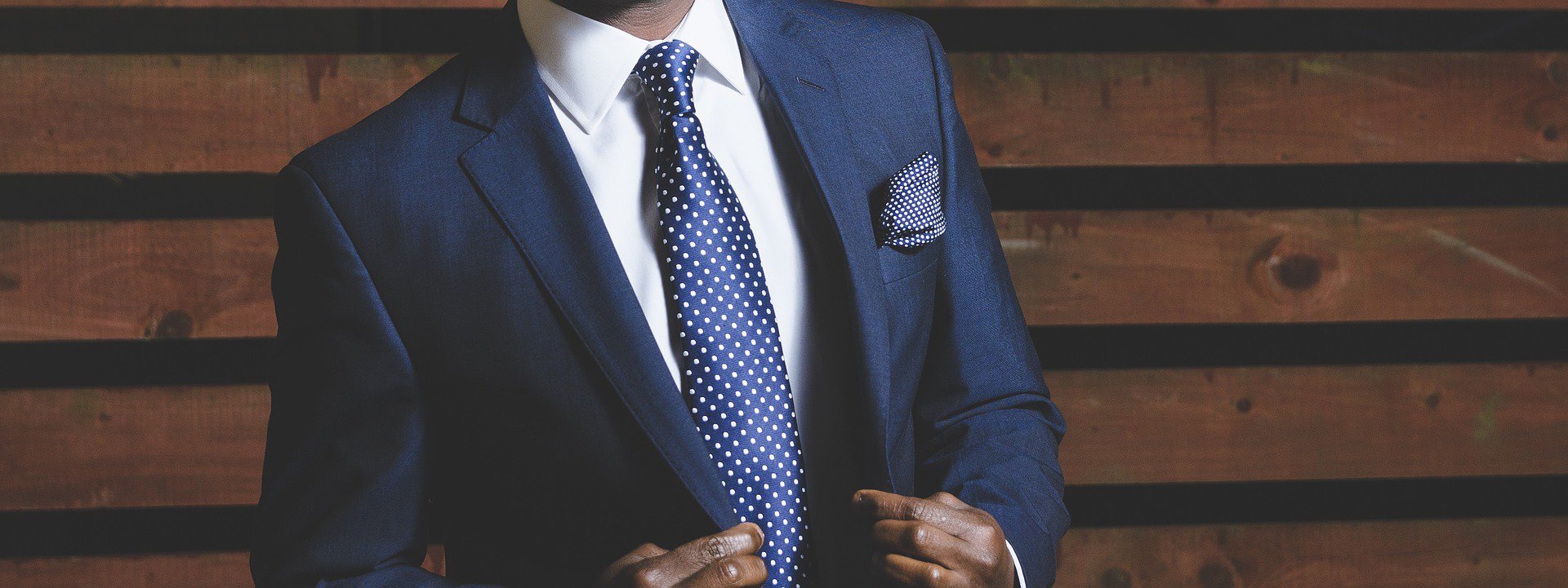 man wearing a blue jacket with white shirt and blue tie