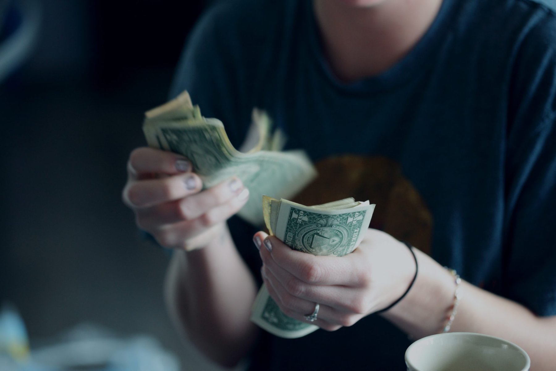 a womans hands counting out bank notes