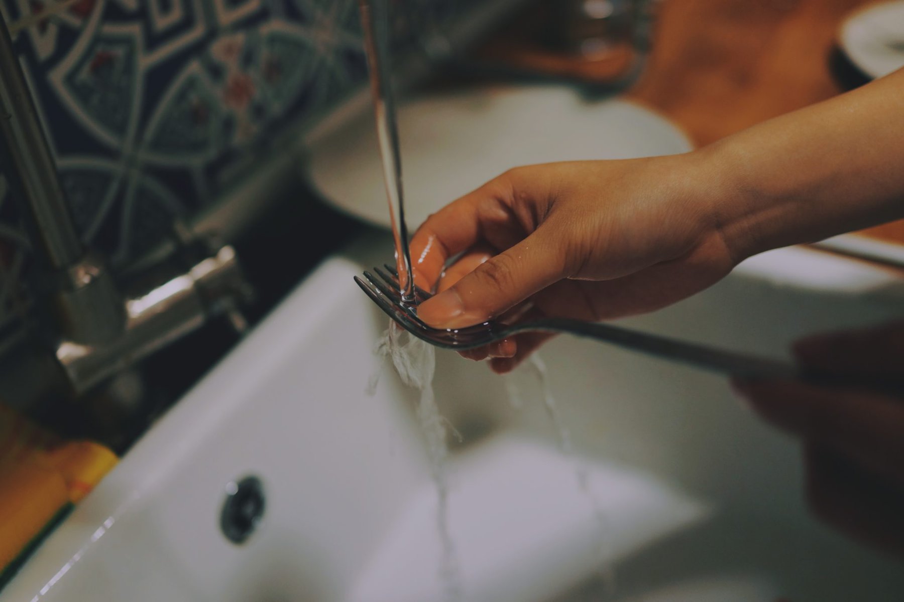 a fork being washed in running water