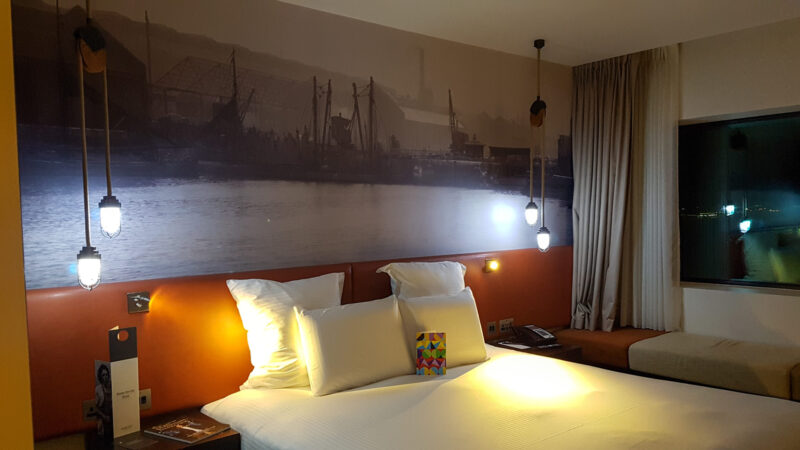 hotel room with double bed and hanging ceiling lights lit up in the dark in the pullman hotel liverpool