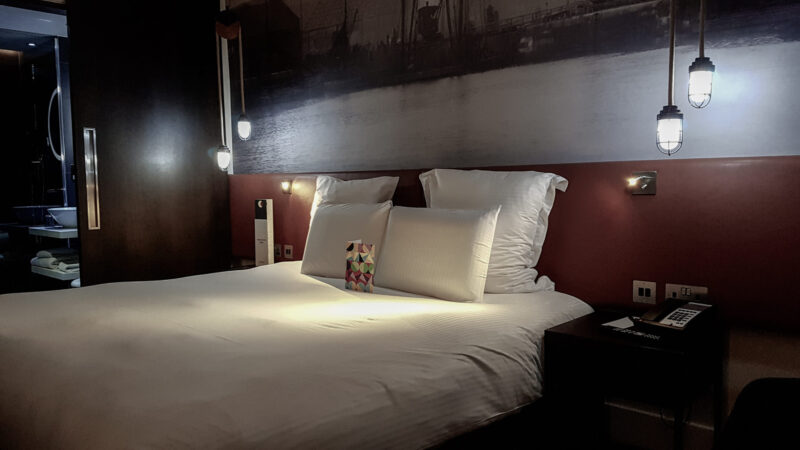 a kingsize bed with white bed linen with a bathroom in view in the pullman hotel liverpool