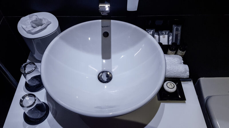a close up image of a round sink basin and toiletries in the pullman hotel liverpool