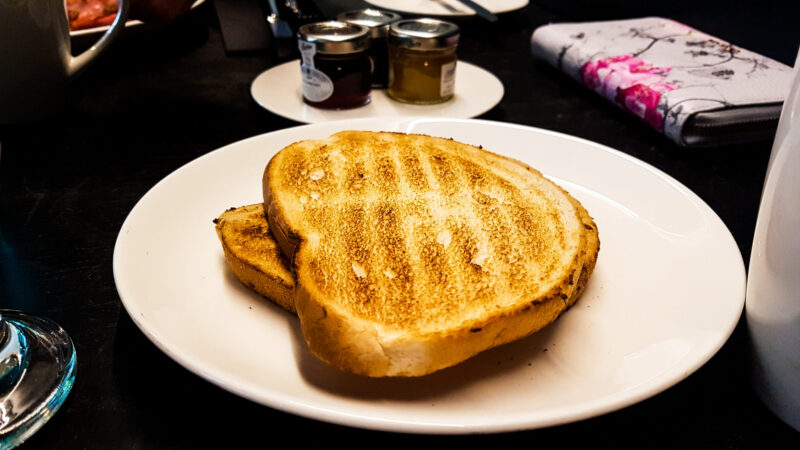 two slices of toast on a plate with jam in the background for breakfast servings at the pullman hotel liverpool