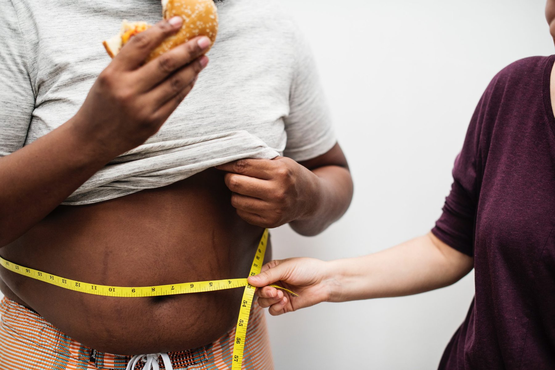 a person eating with tape measure around their waist