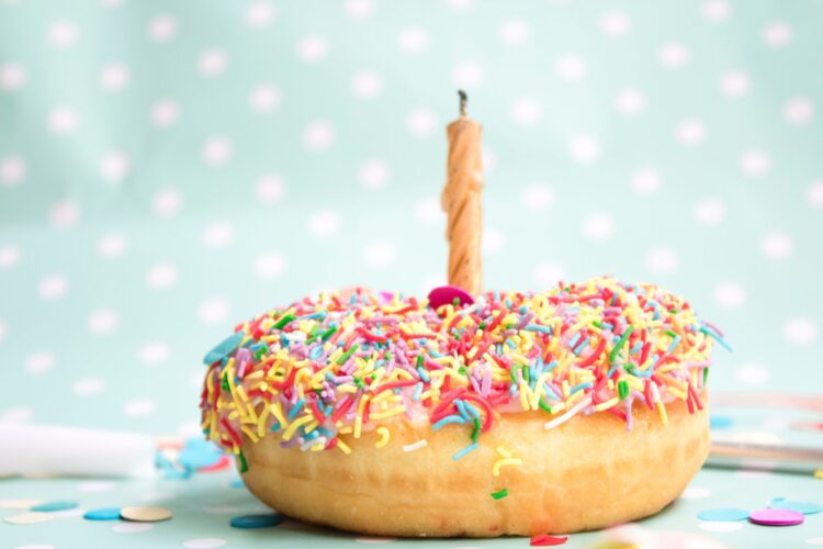 a doughnut with sprinkleso n the top and a candle in the middle