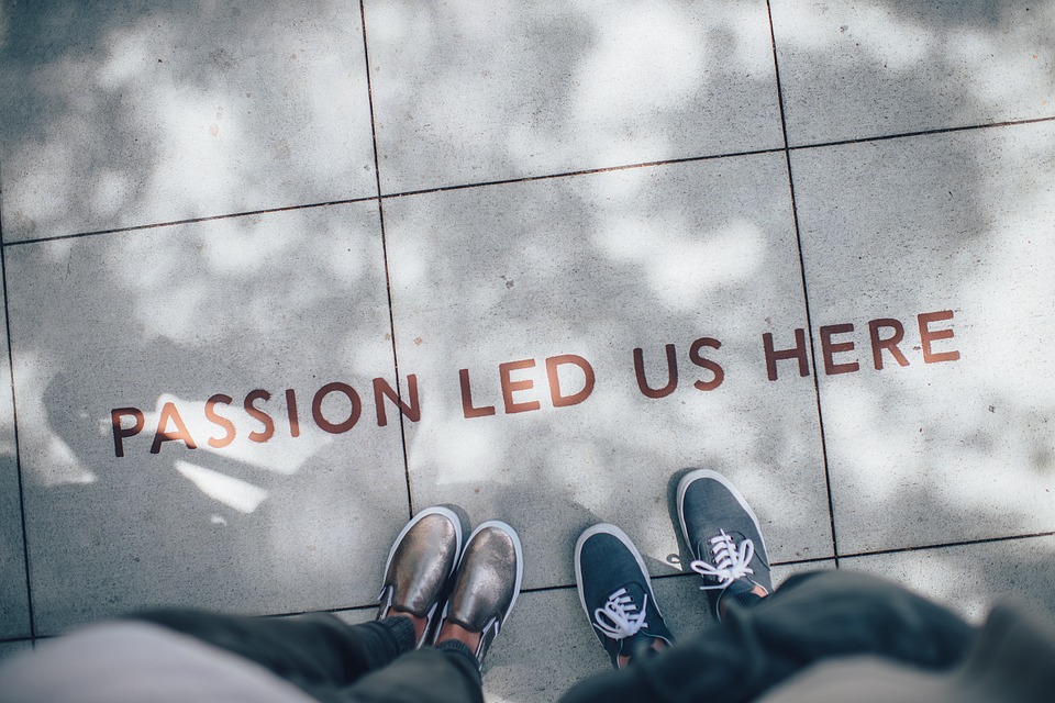 shoes standing on pavement with the words passion led us here on the ground