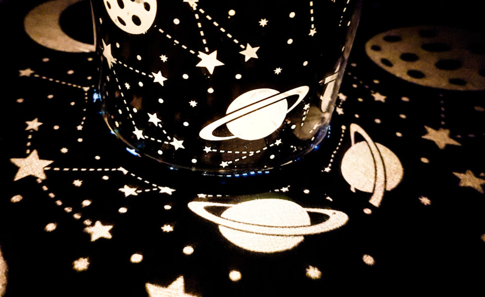 light reflections of planets and stars against a black background