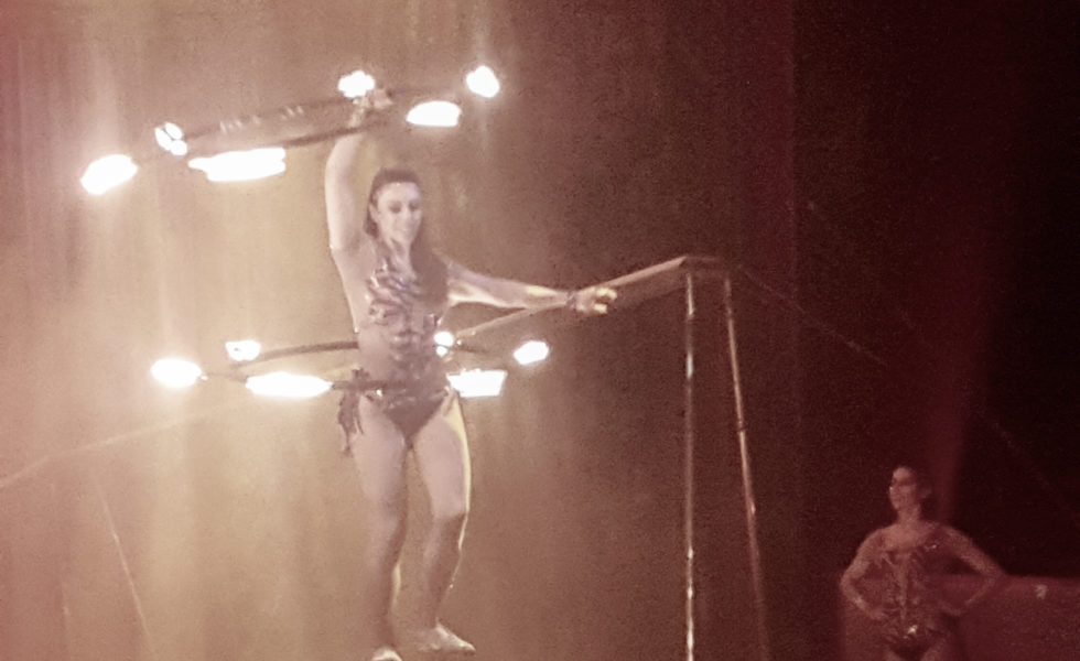 circus performer with hoops of fire on a ball