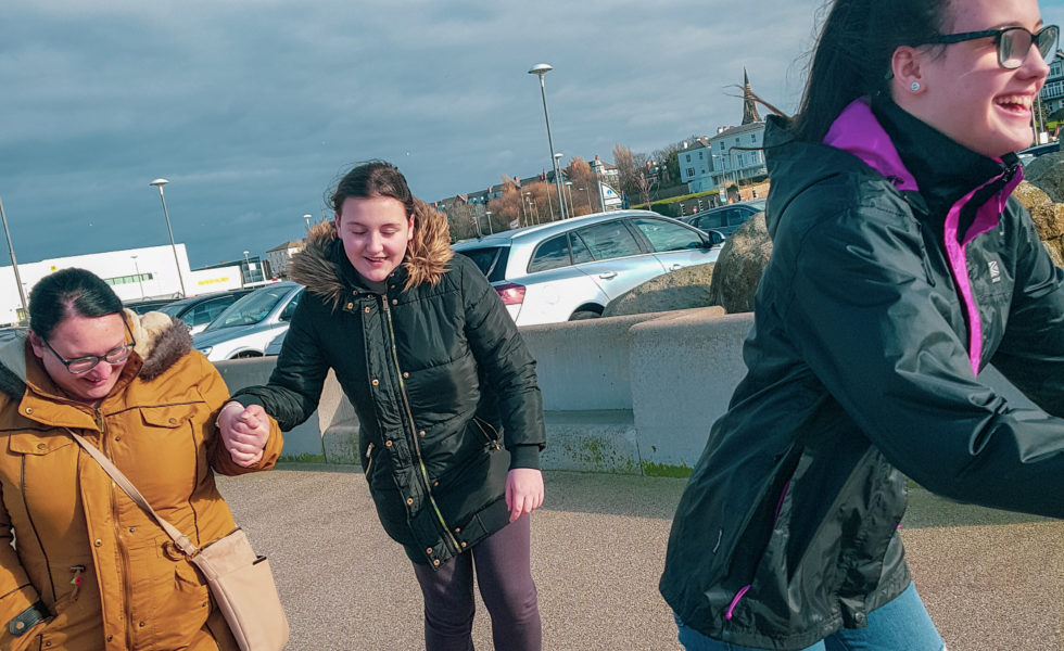 two teenagers and a woman practising roller skating