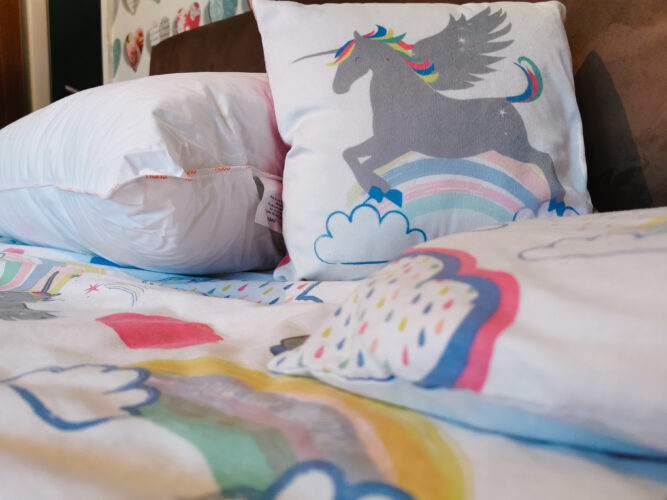 a plump nanu pillow on a unicorn bedding set with pillow and small scatter cushion