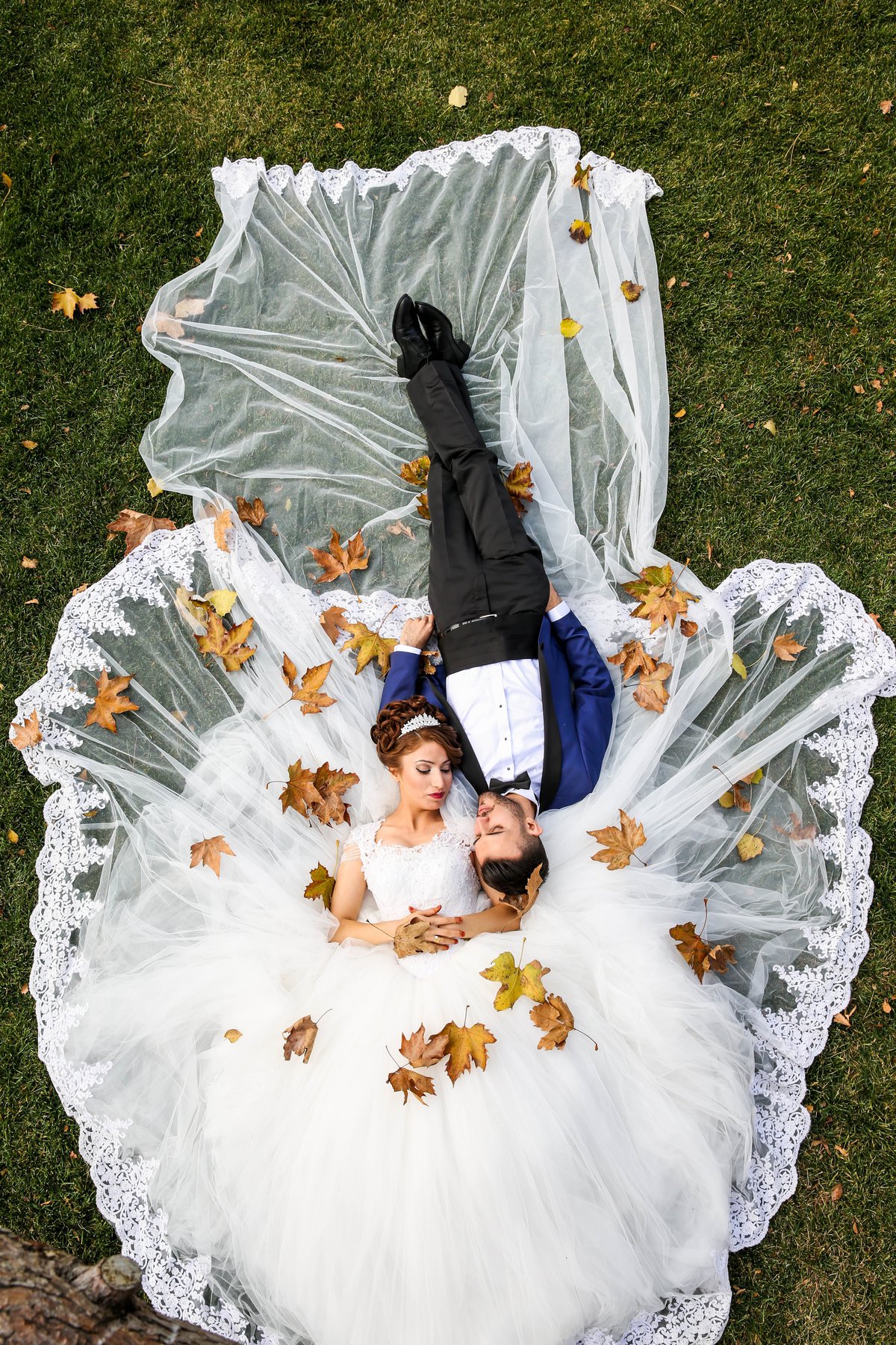 aerial shot of man and woman in wedding outfits lying on the ground