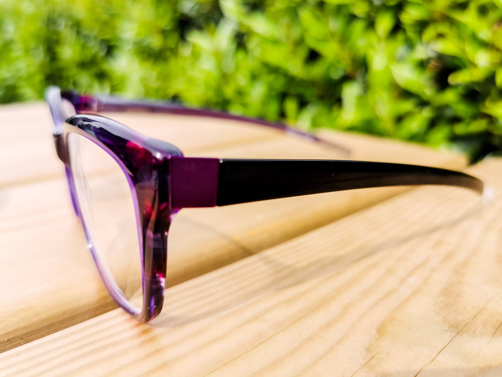 a pair of purple glasses on a wooden table