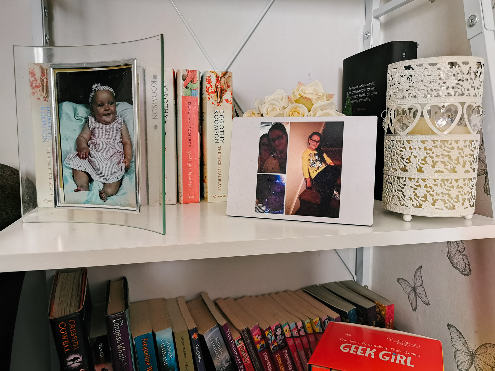 a shlving unit with a selection of baby images and books