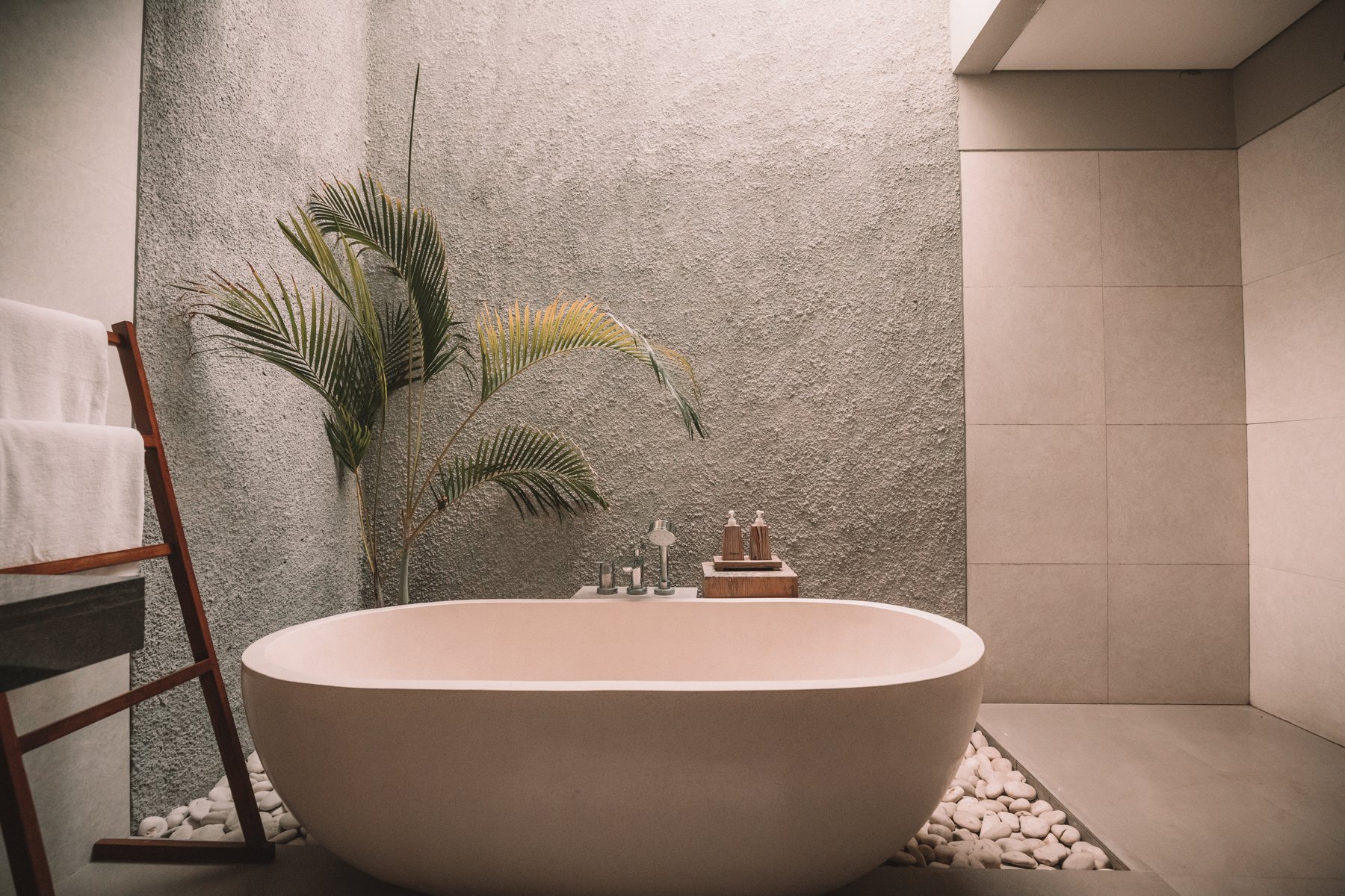 a tiled designer bathroom with a bathtub in the centre of the room