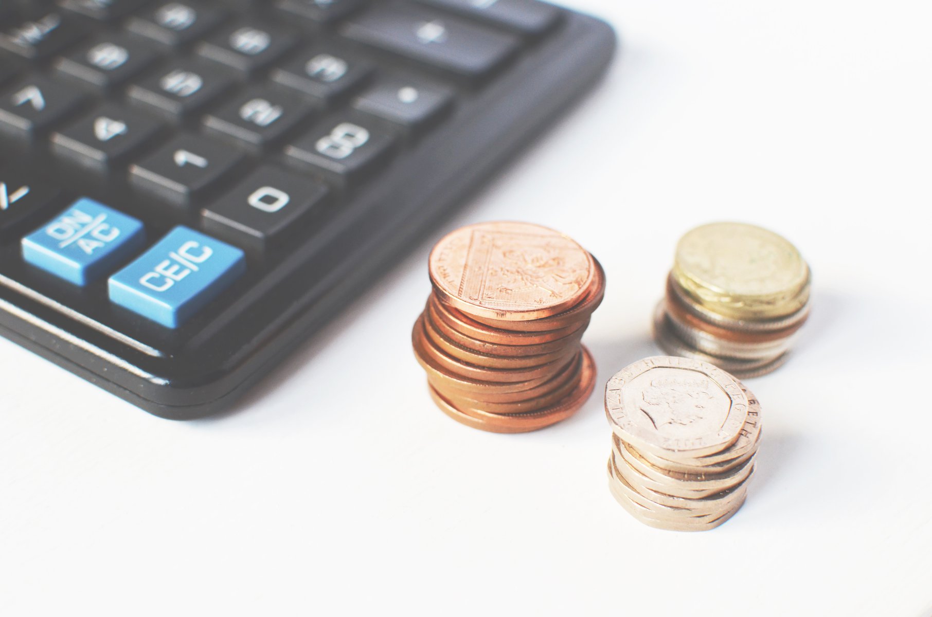 piles of coins next to a calculator