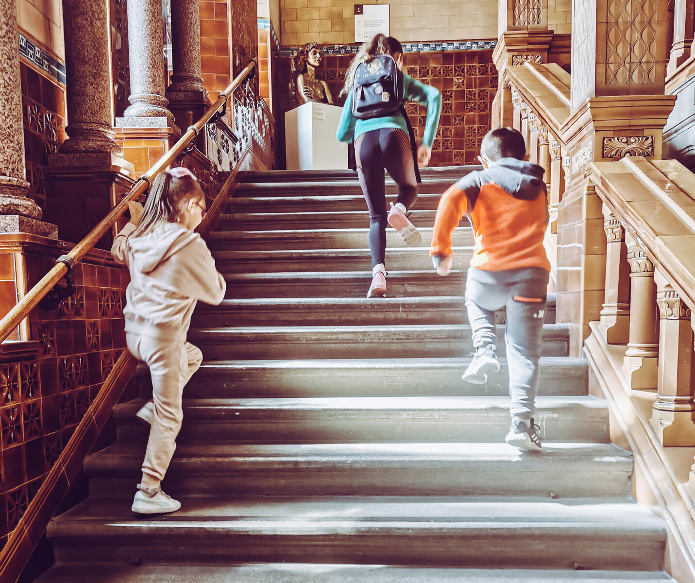 back of three kids running up a staircase at the victoria gallery and museum