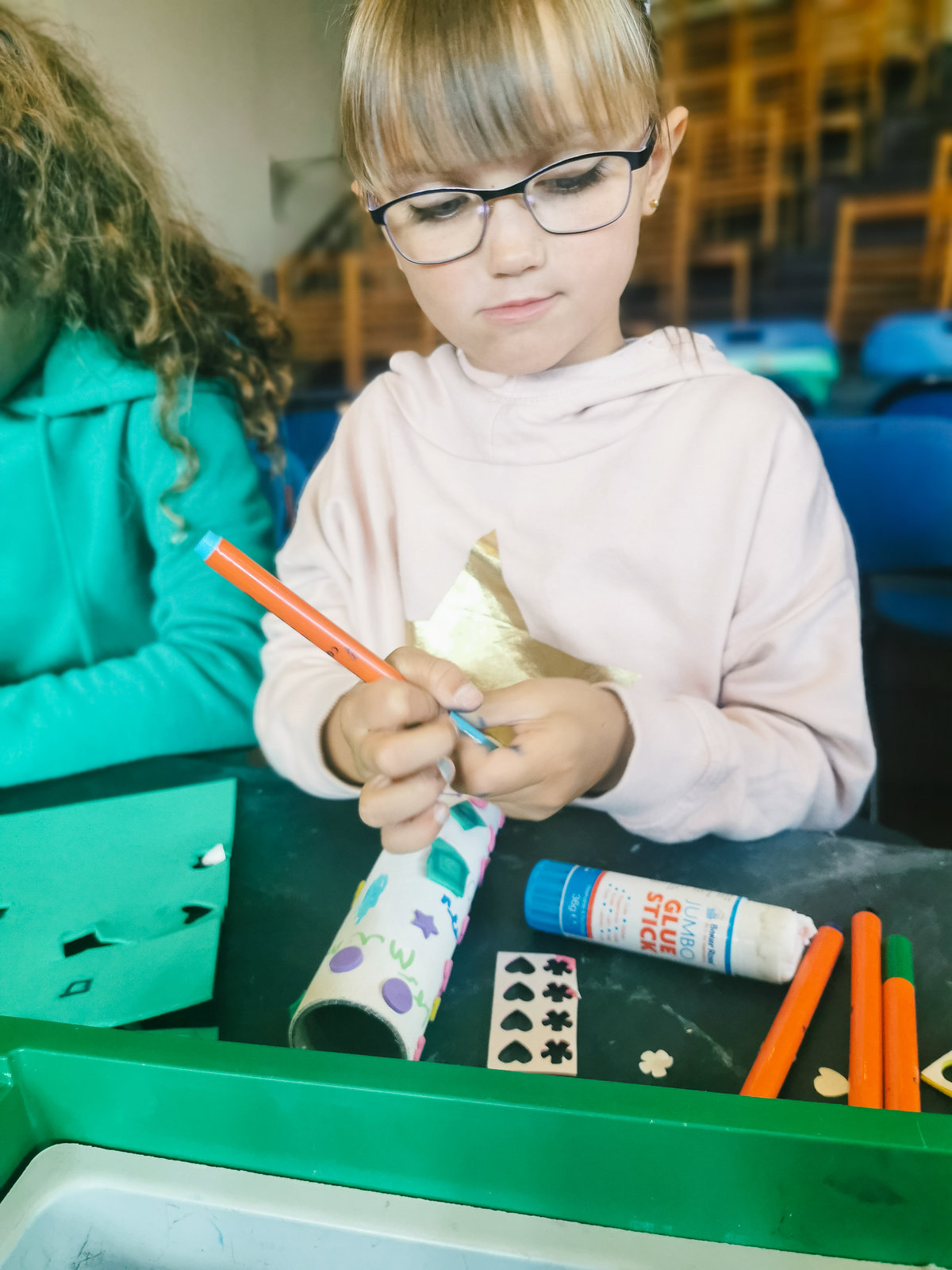 young girl wearing glasses crafting