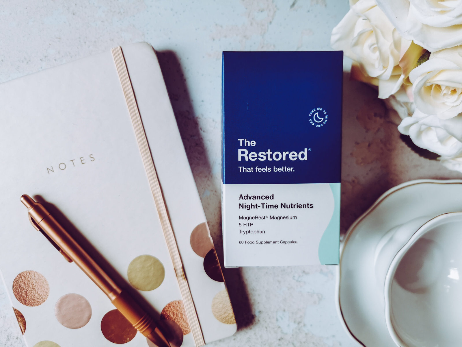 a bottle of the restored supplements in a flat lay set up