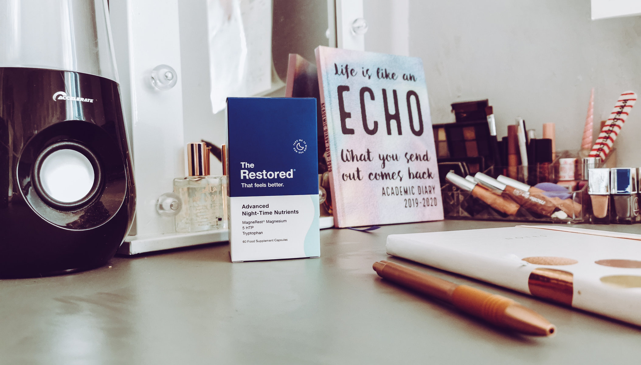 a bottle of the restored advanced night sleep aid on a desk with notebooks