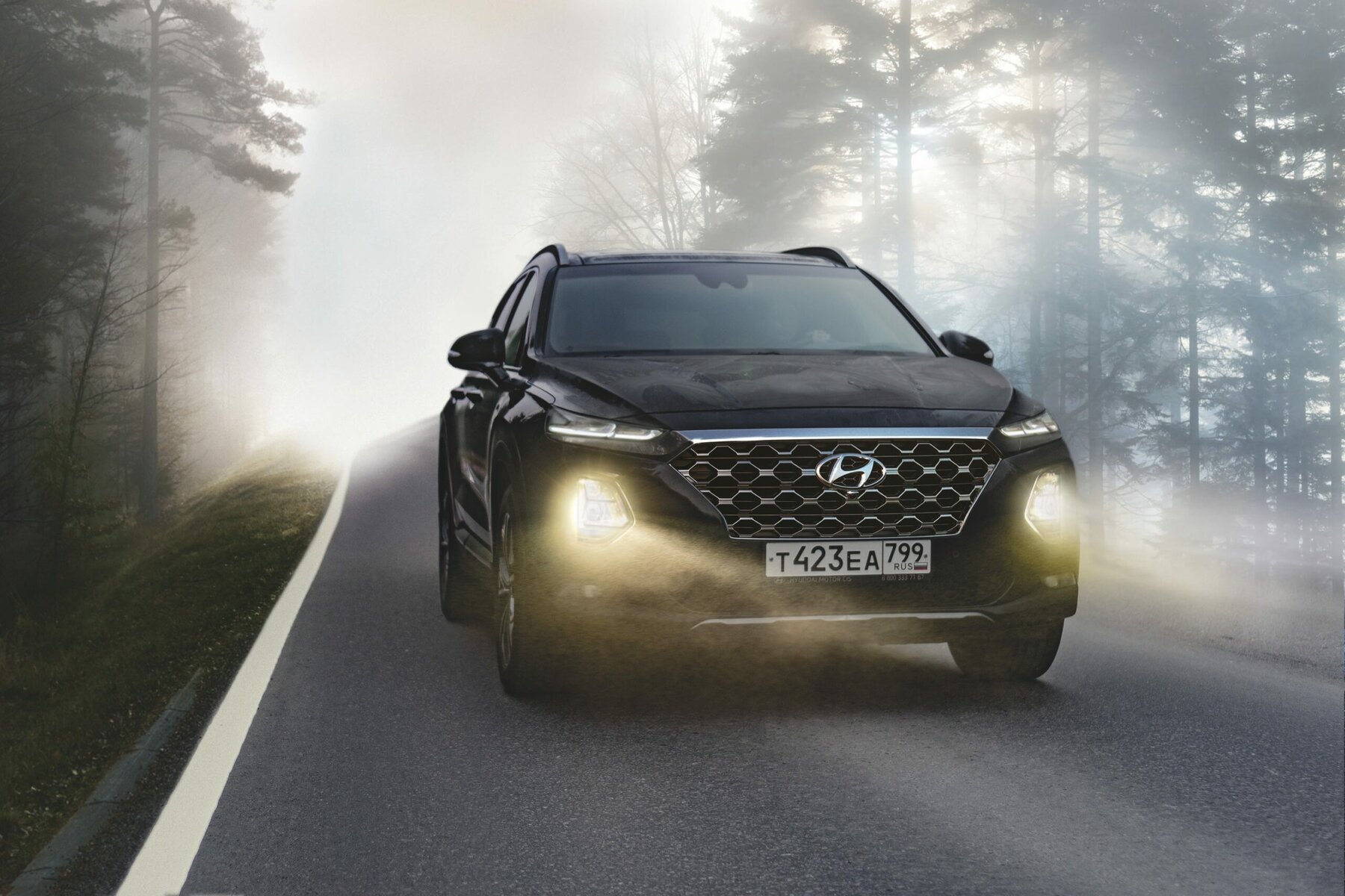 black suv driving in foggy conditions with lights on