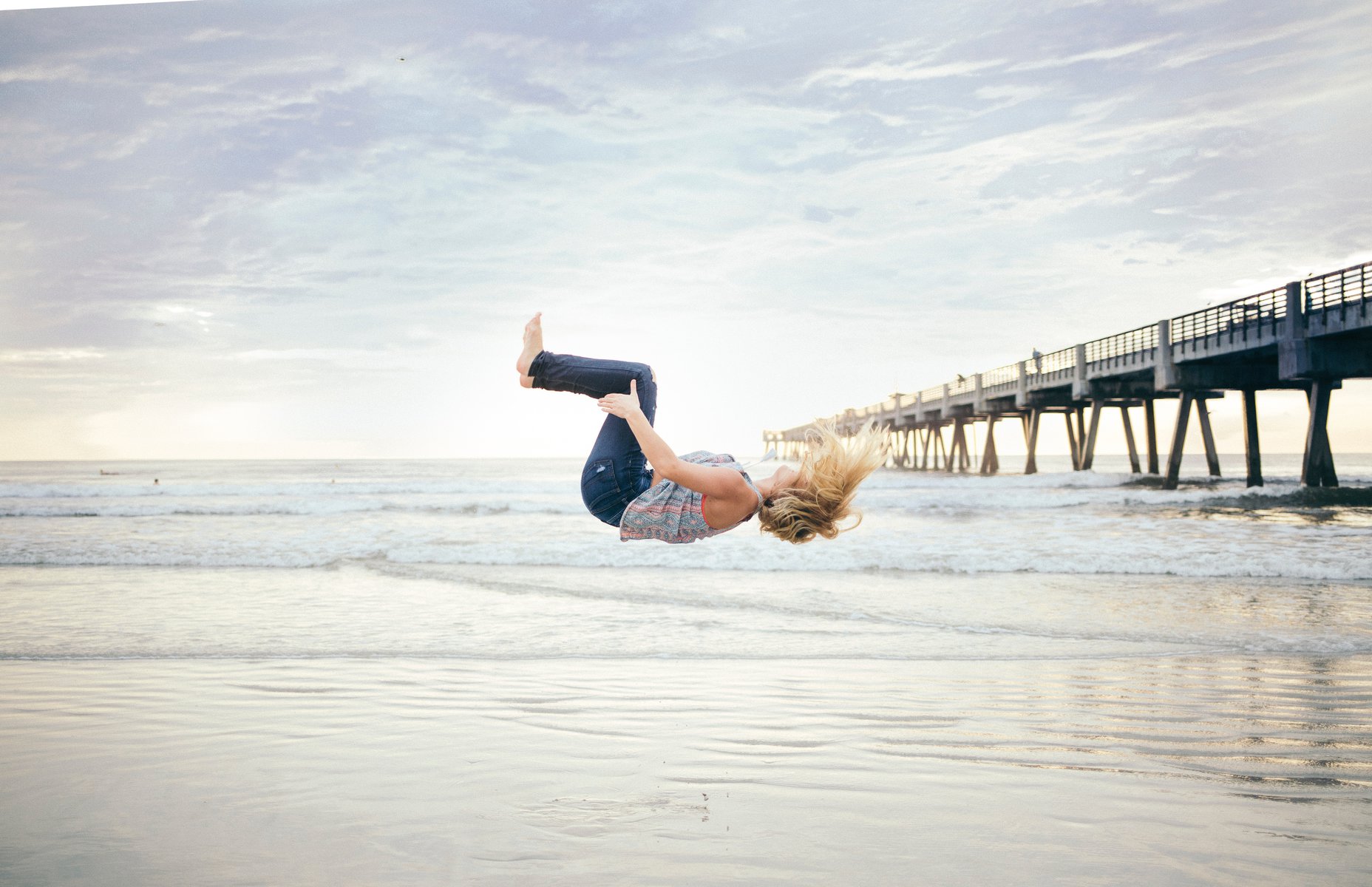 woman doing a backflip on a beach