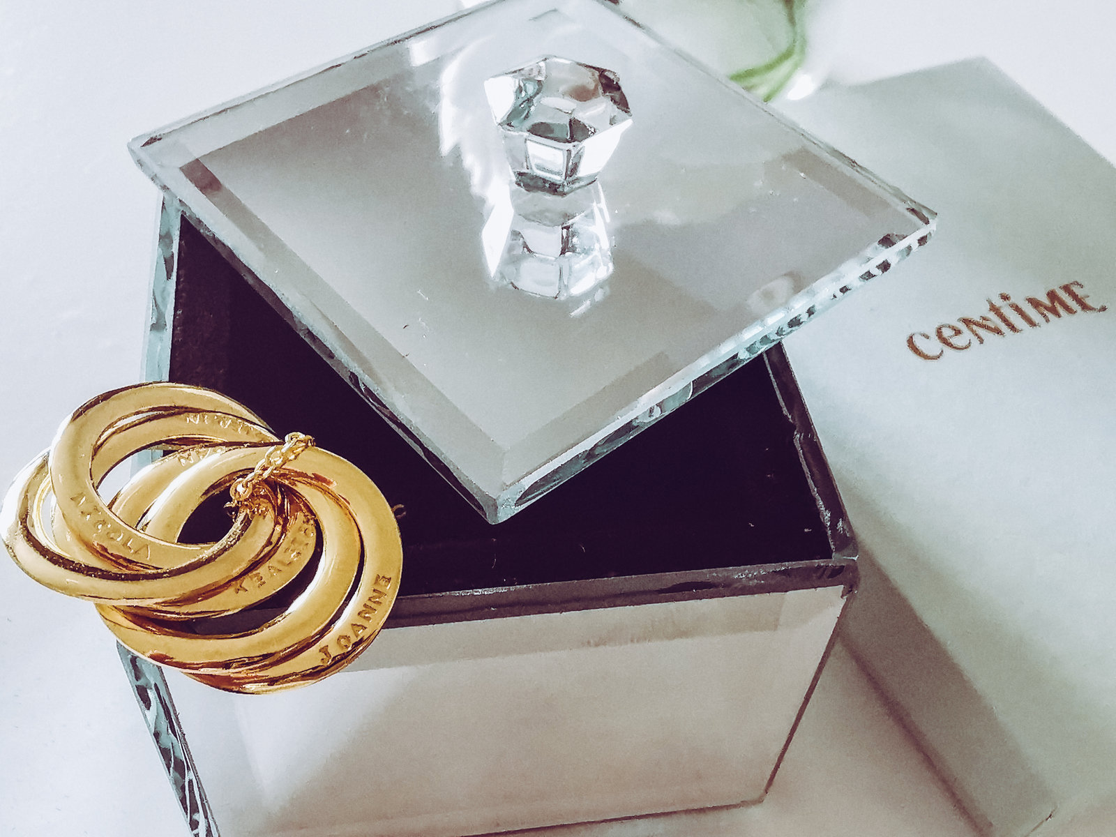 a gold 5 ring mother's necklace on a glass trinket from centime jewellery