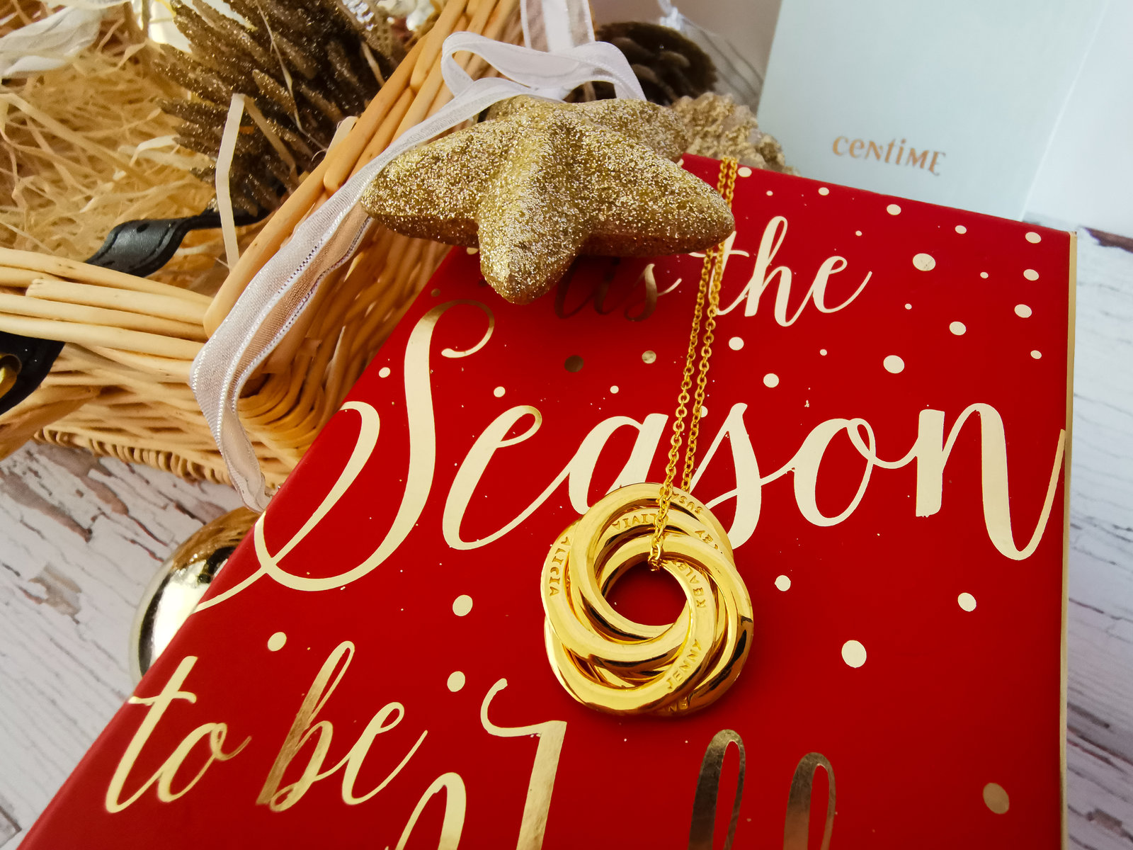 a 5 ring necklace onto op of Christmas decorative box