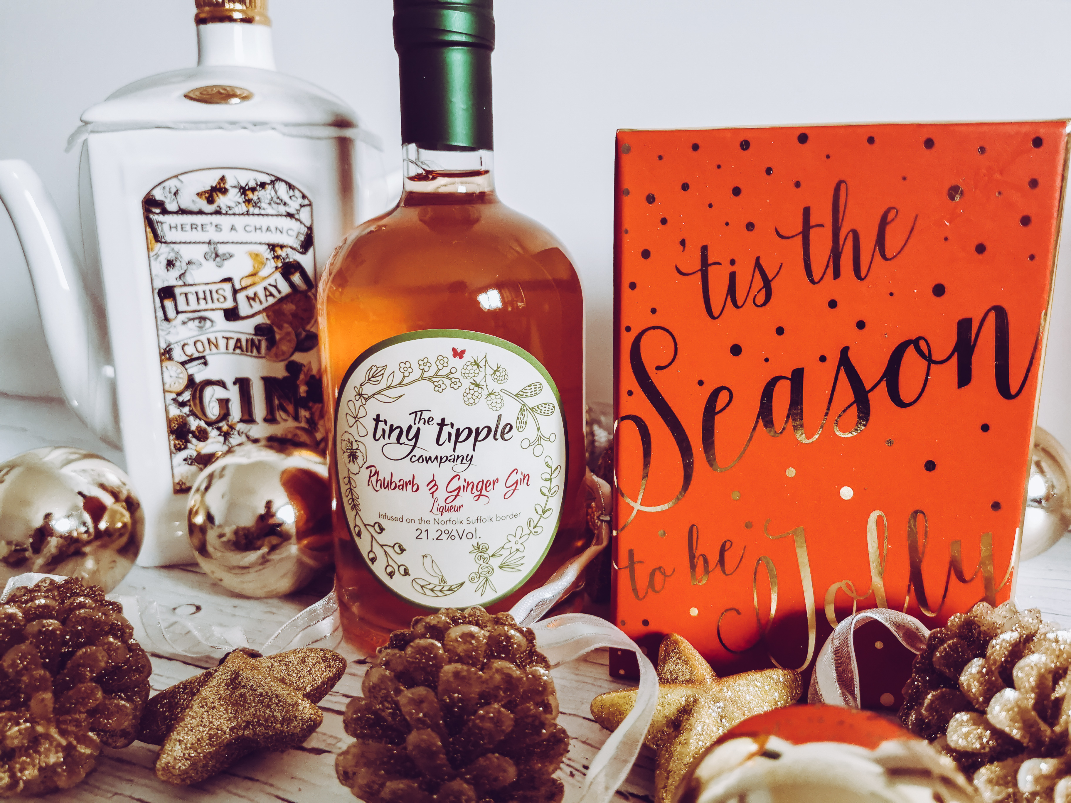 a bottle of rhubard and ginger gin in a xmas themed set up