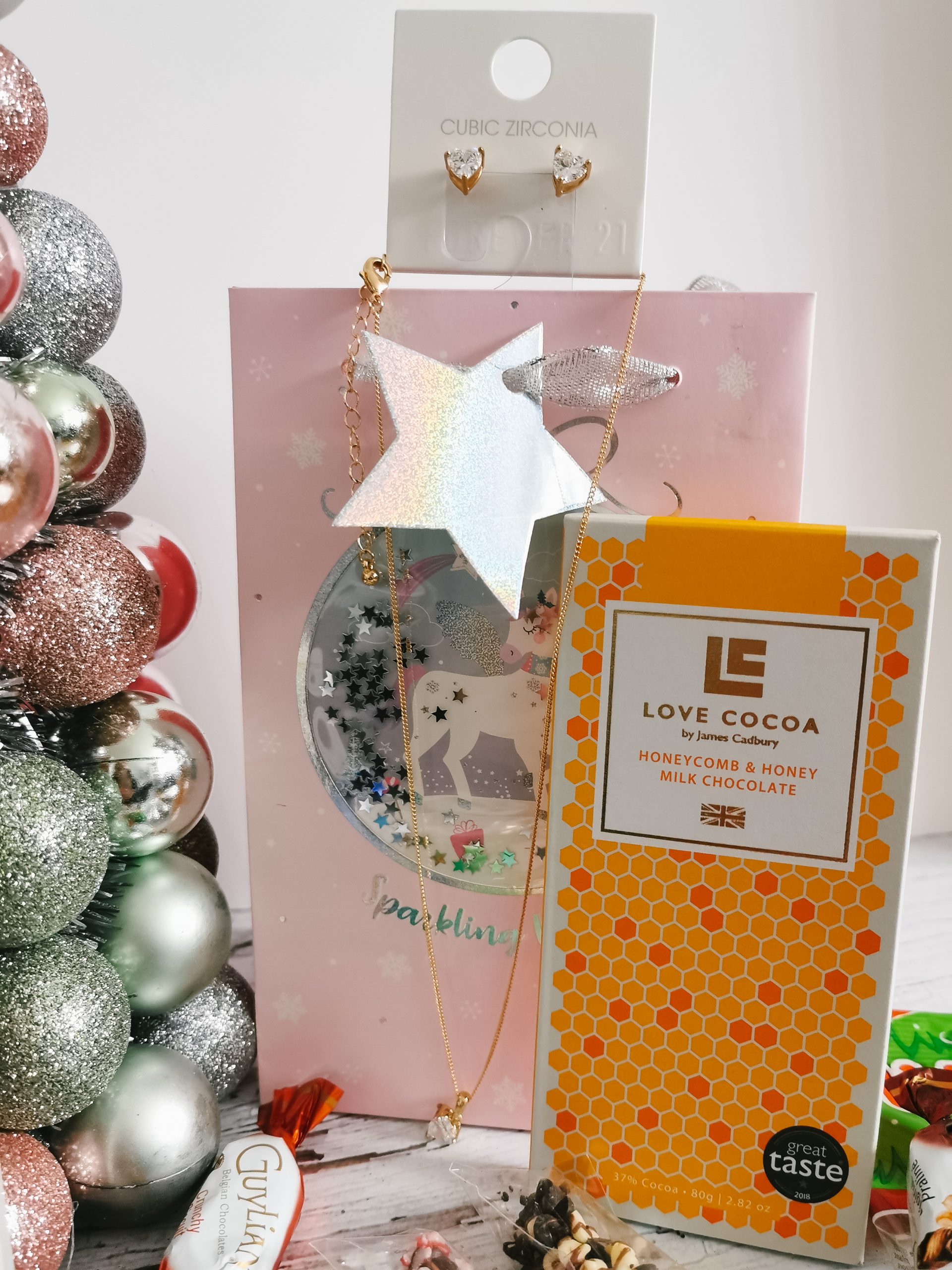 a bar of chocolate standing against a gift bag with some jewellery on it