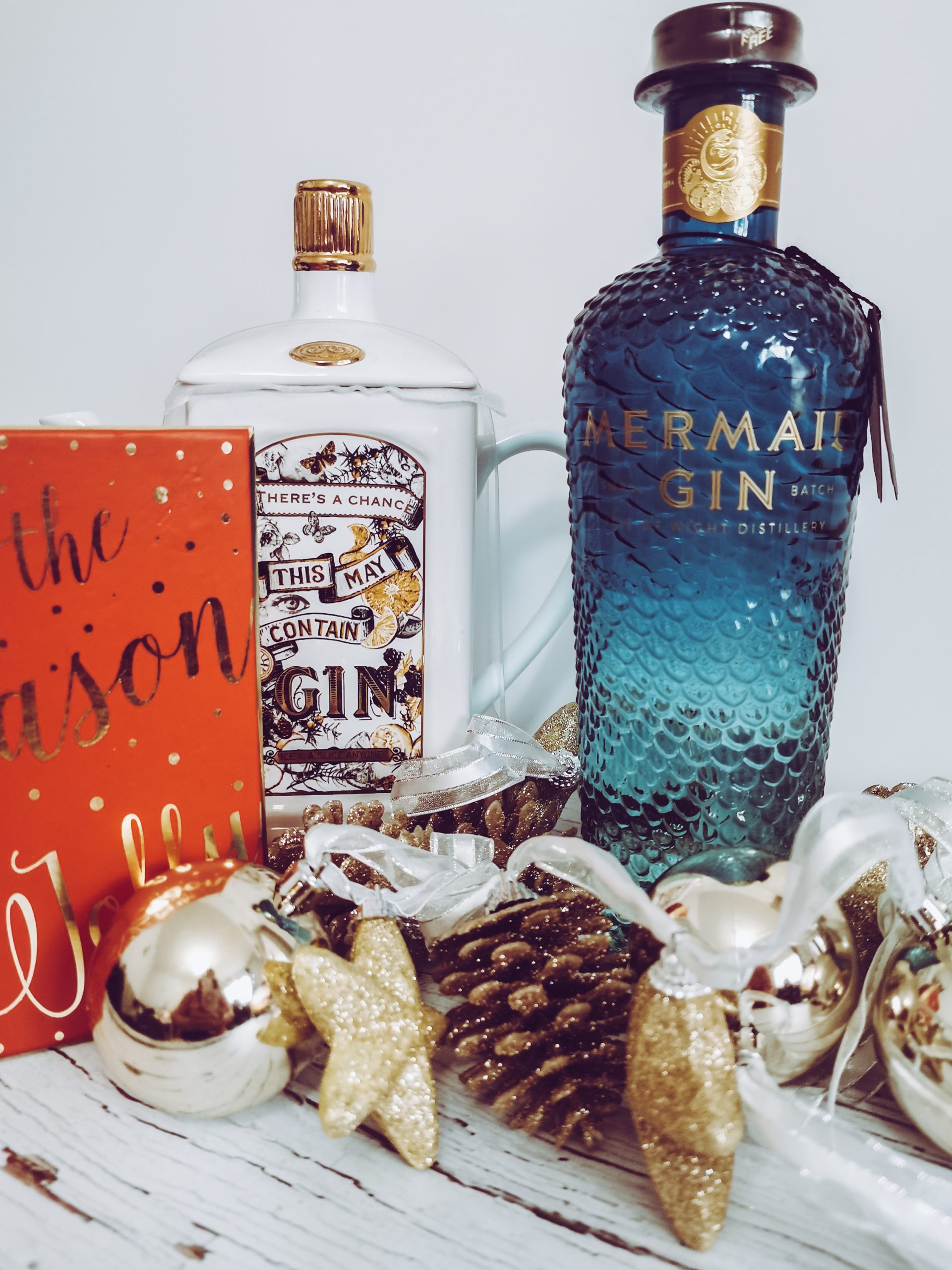 a set up image of mermaid gin with christmas themed items around it