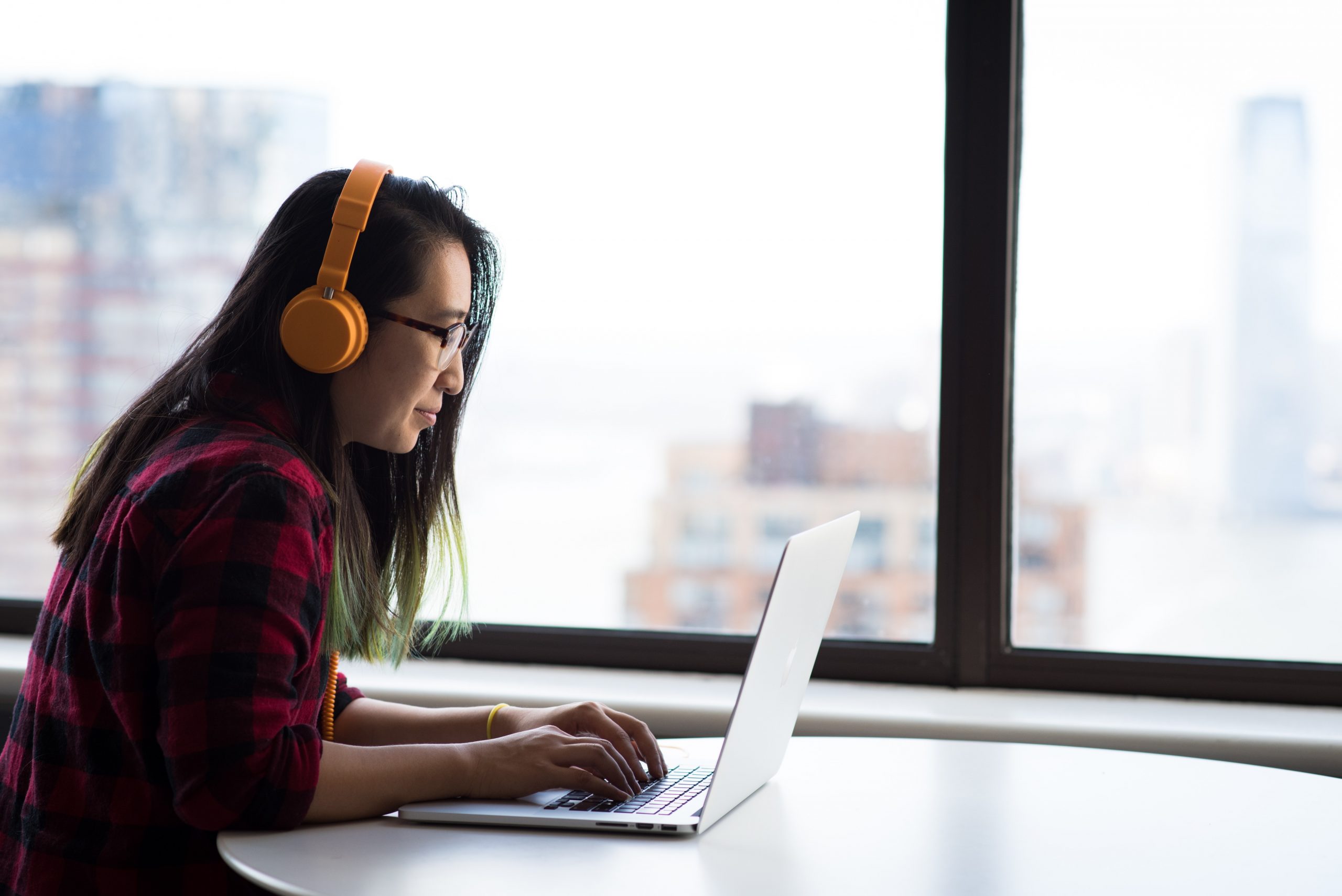 woman using her laptop wearing headphones