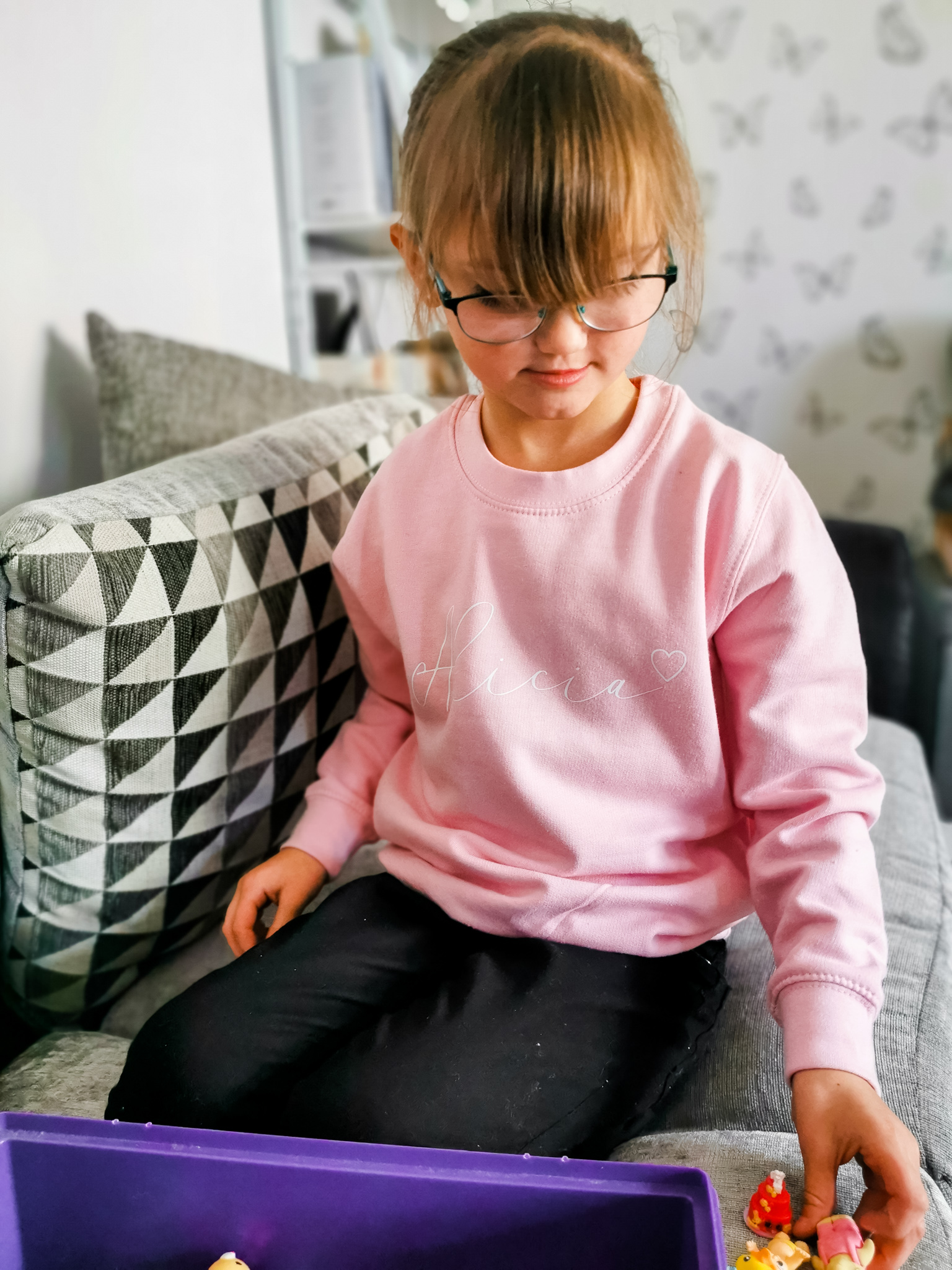 young girl in sitting position wearing a pink personalised jumper from cookie dough kids