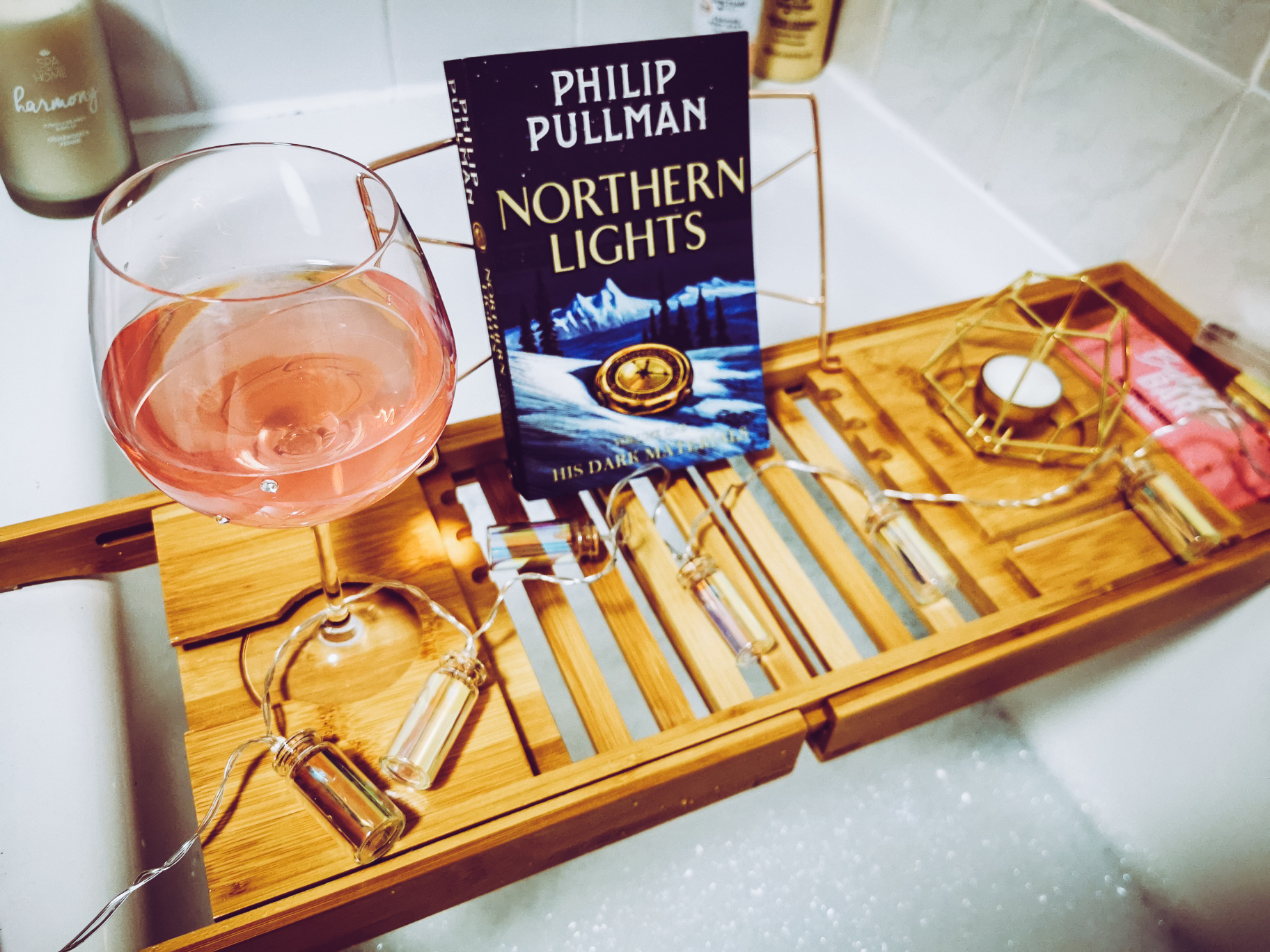 wooden bath caddy with wine glass book and candle