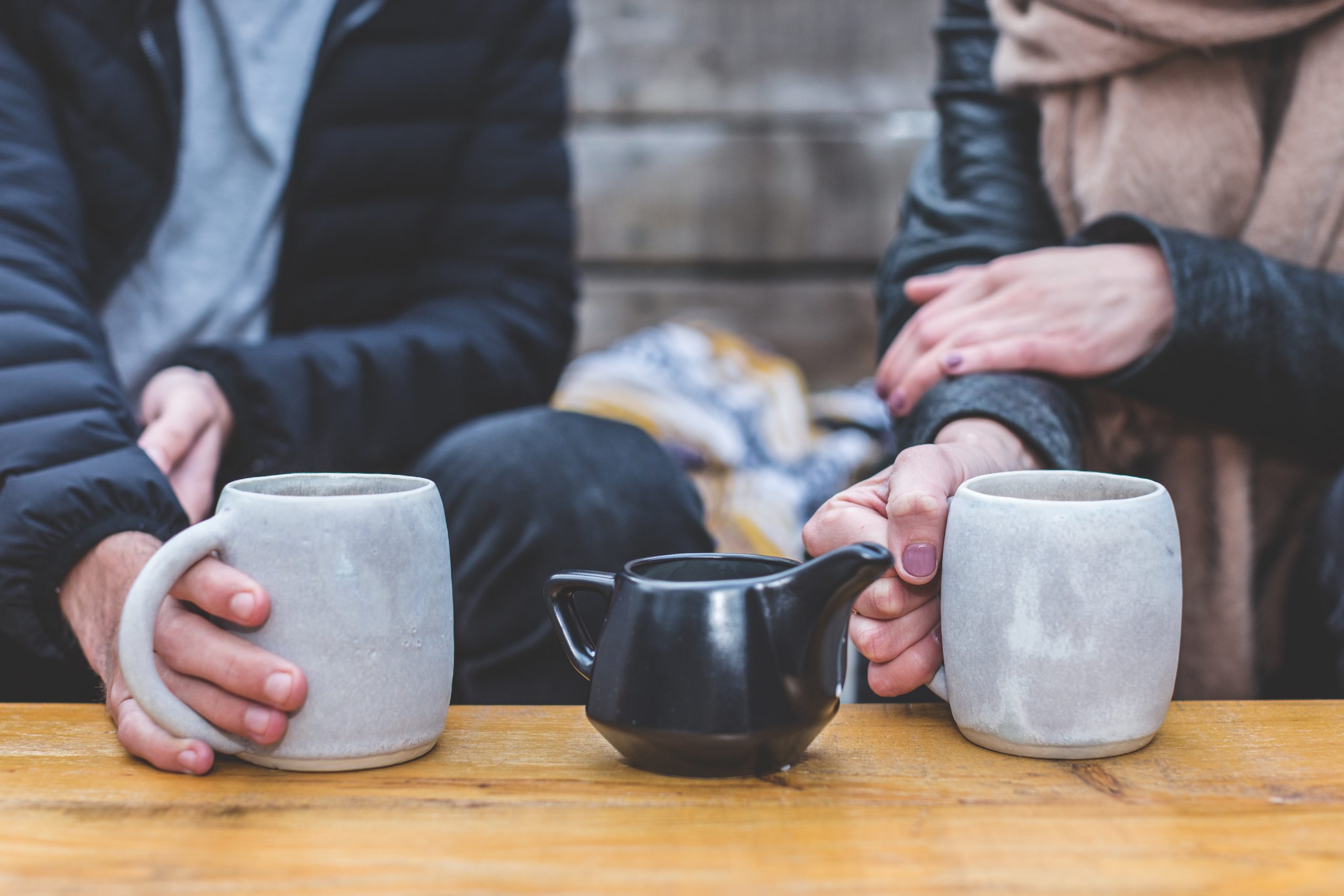 man and woman holding mugs