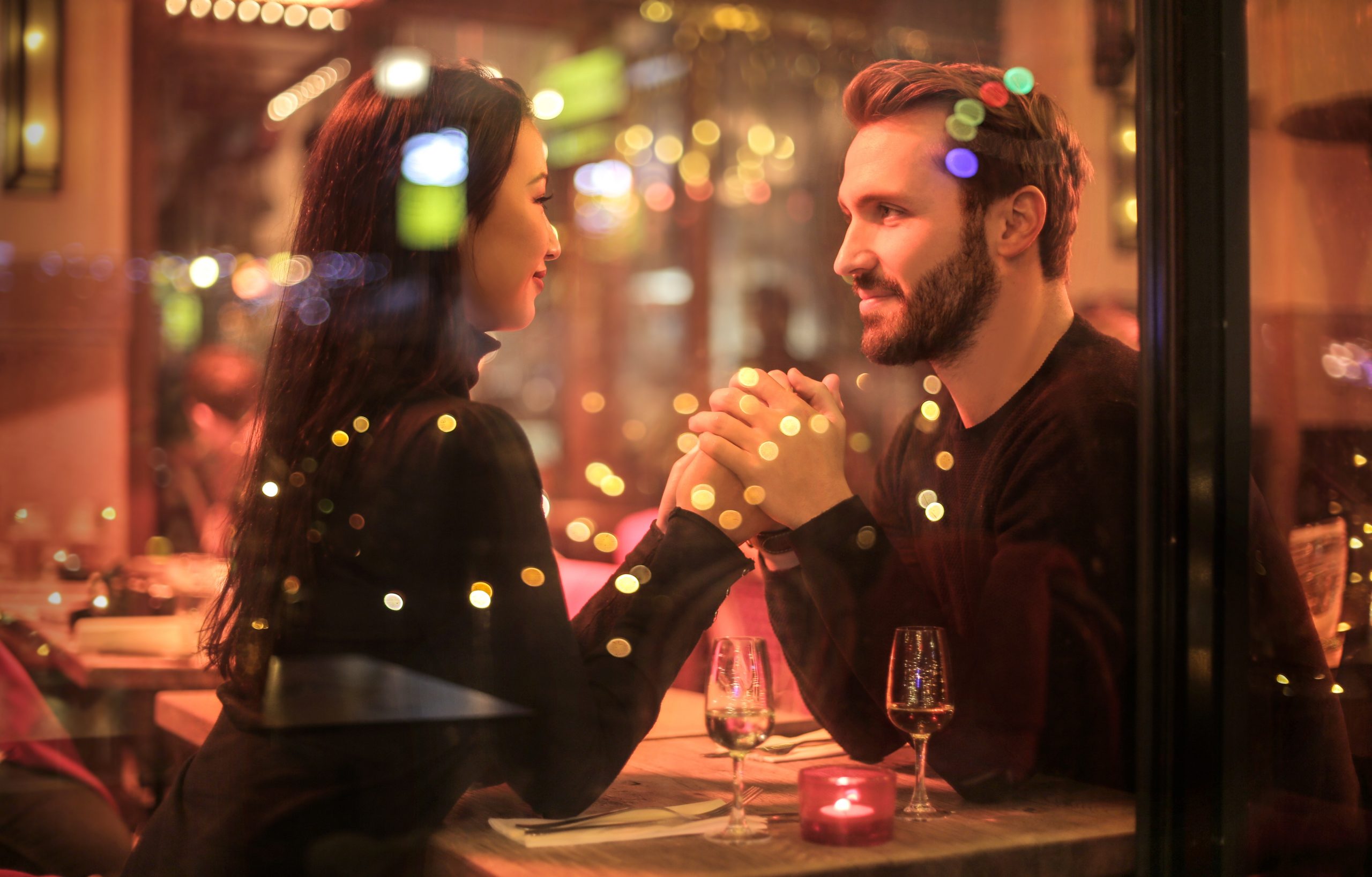blurred focus image of a man and a woman holding hands in a restaurant