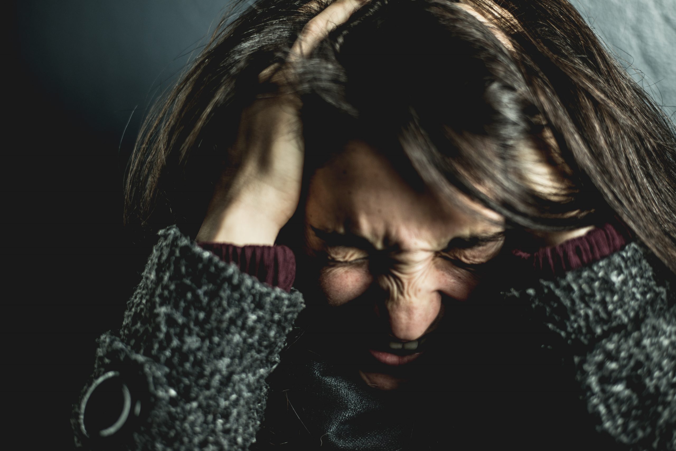 woman holding her head in pain