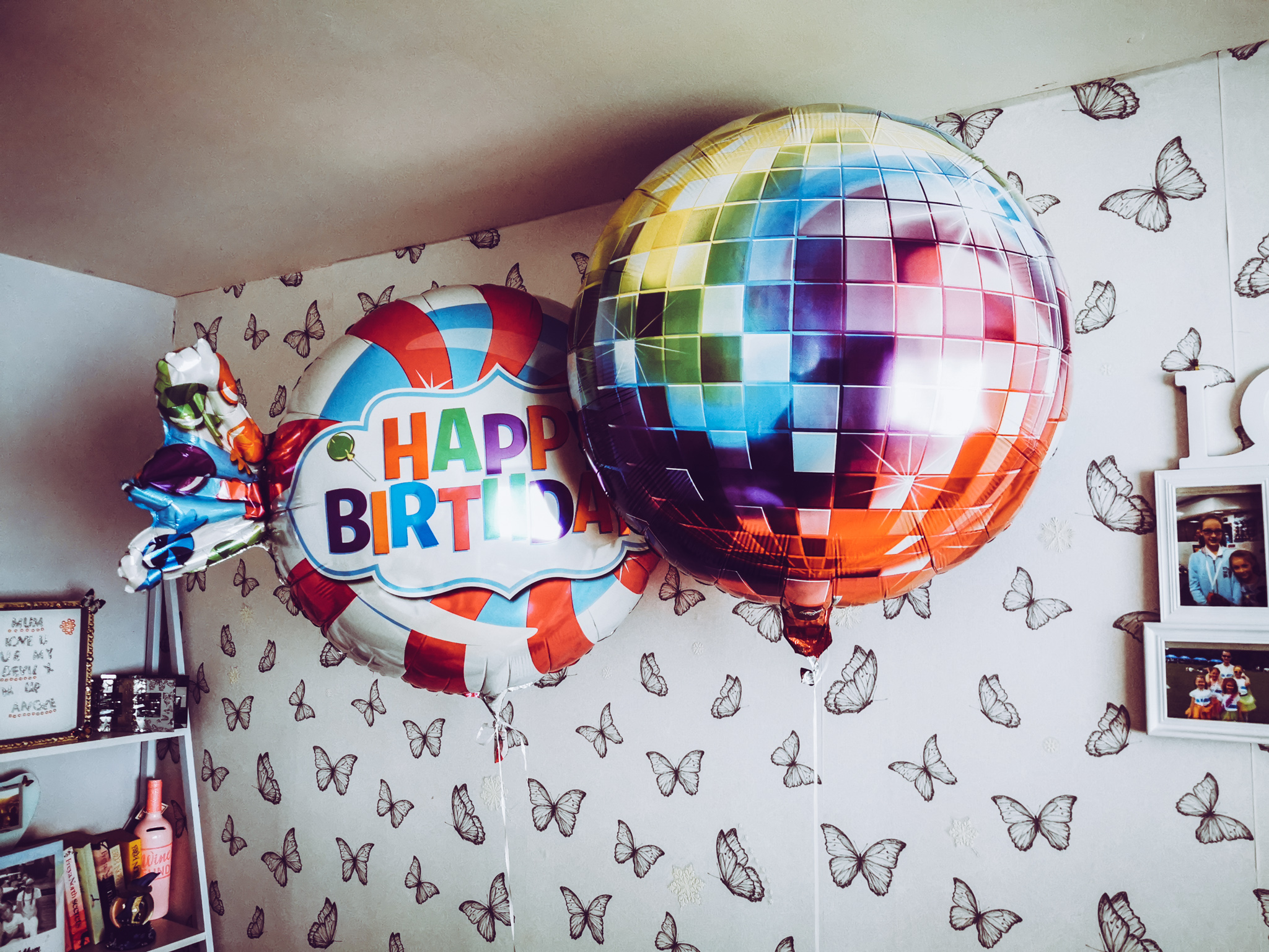 two large helium balloons in the sahpe of a disco ball and a sweet