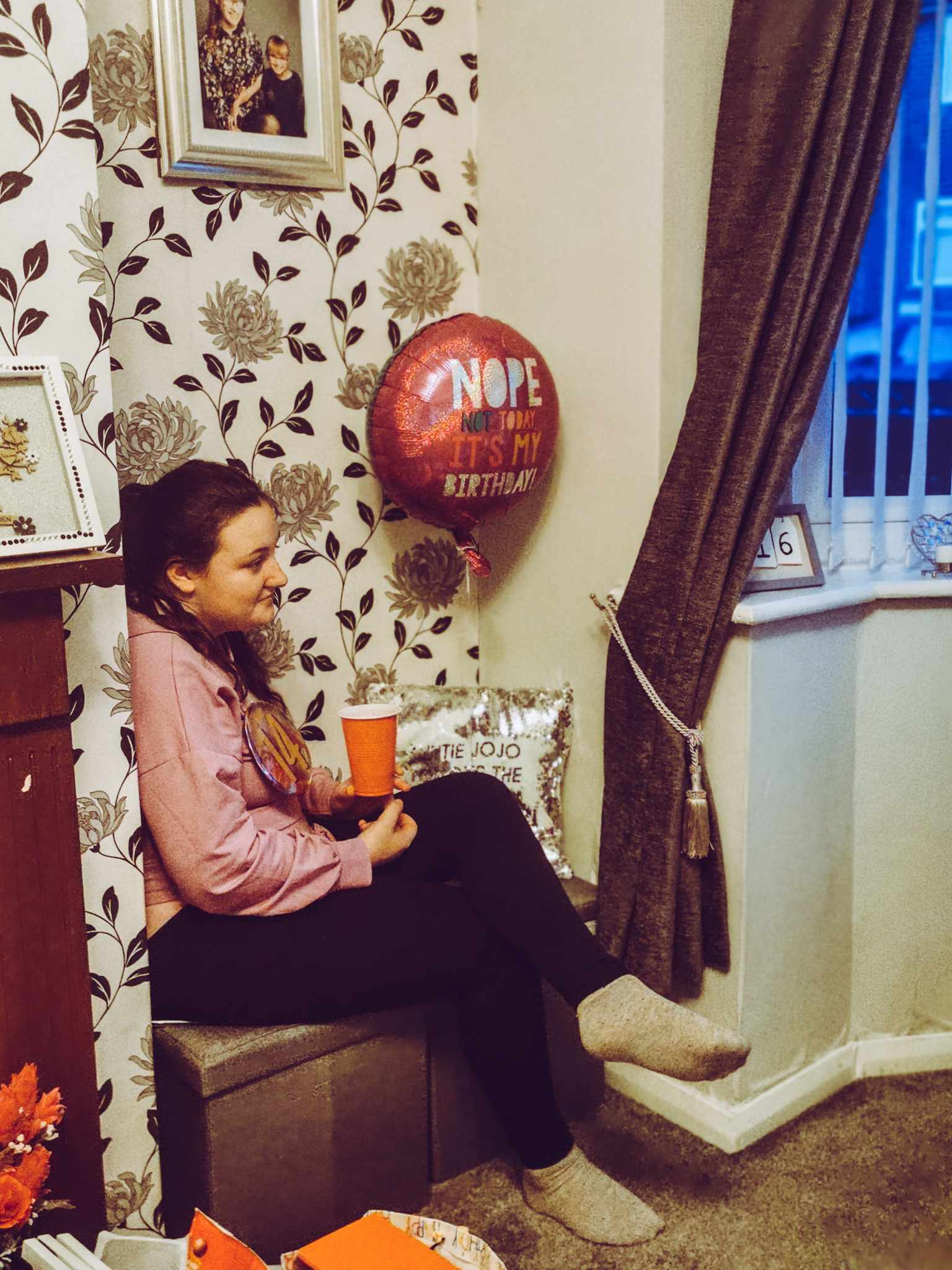 girl sat in a corner with birthday items