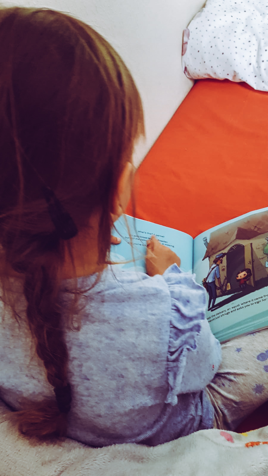 back of a young girl reading a book